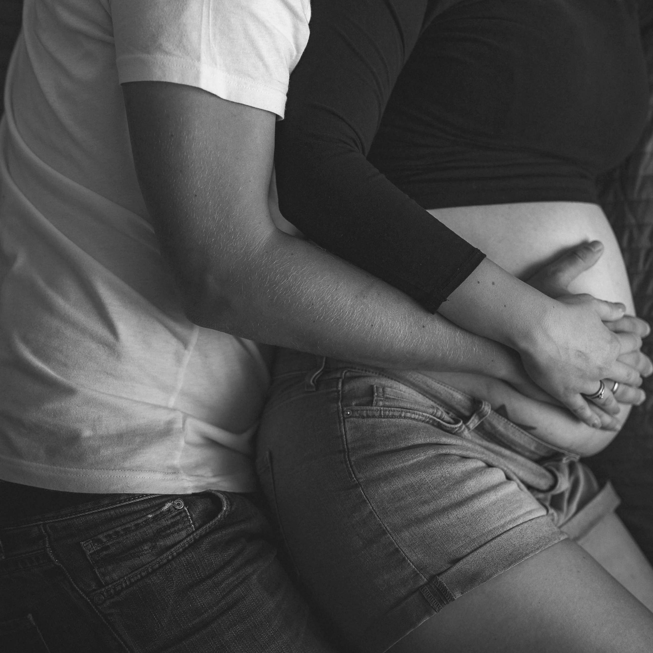 Un homme se blottit contre une femme enceinte dans son lit | Source : Pexels