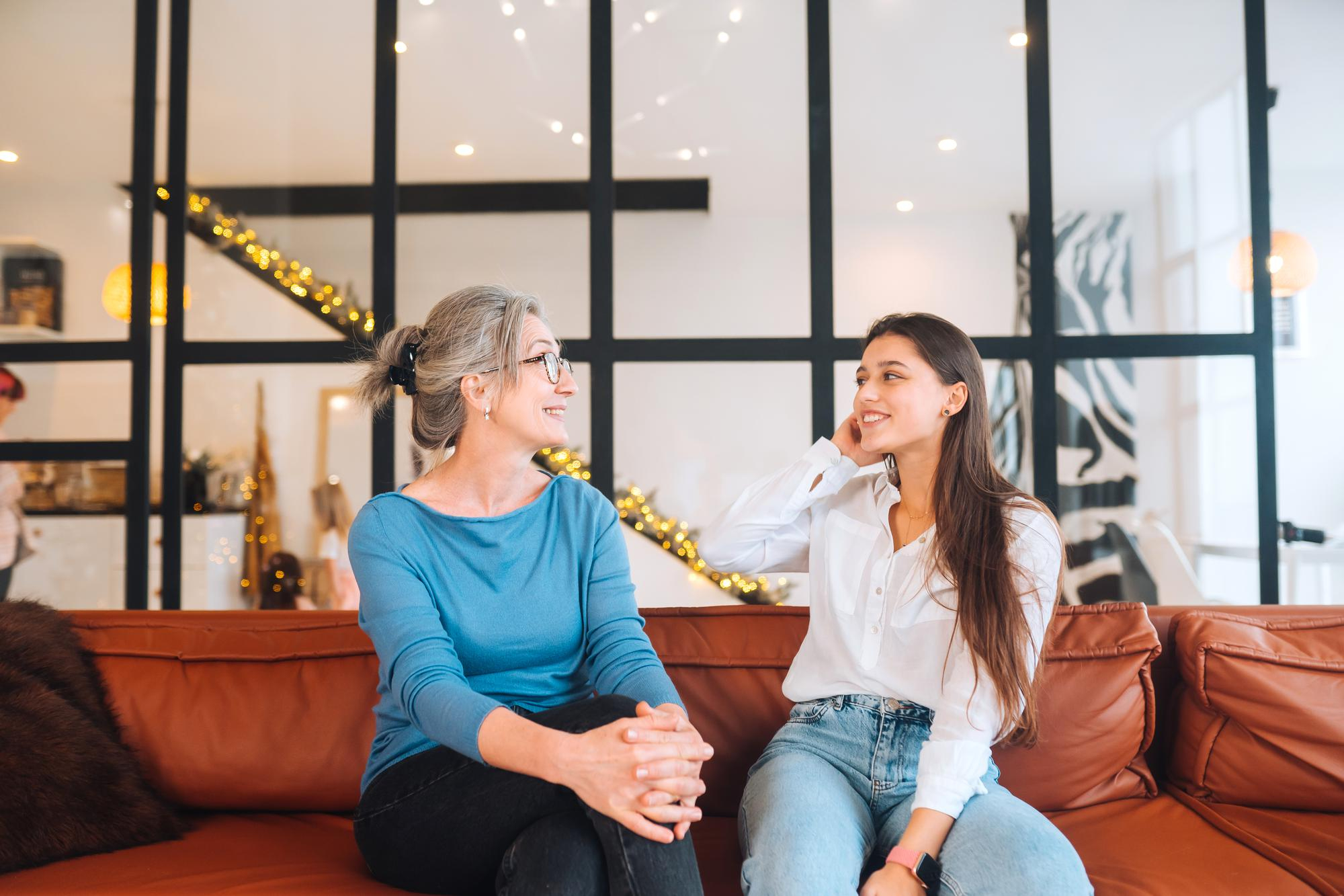 Un duo mère-fille qui discute en étant assis sur un canapé | Source : Freepik