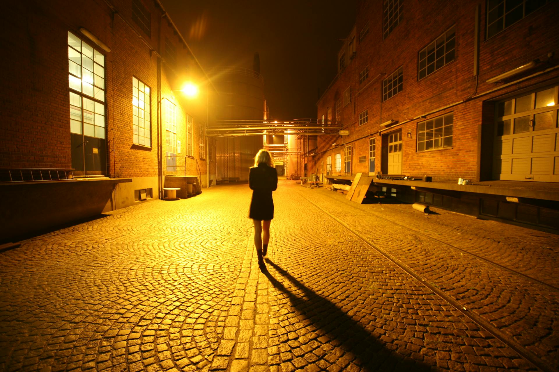 A woman walking down a street at night | Source: Pexels