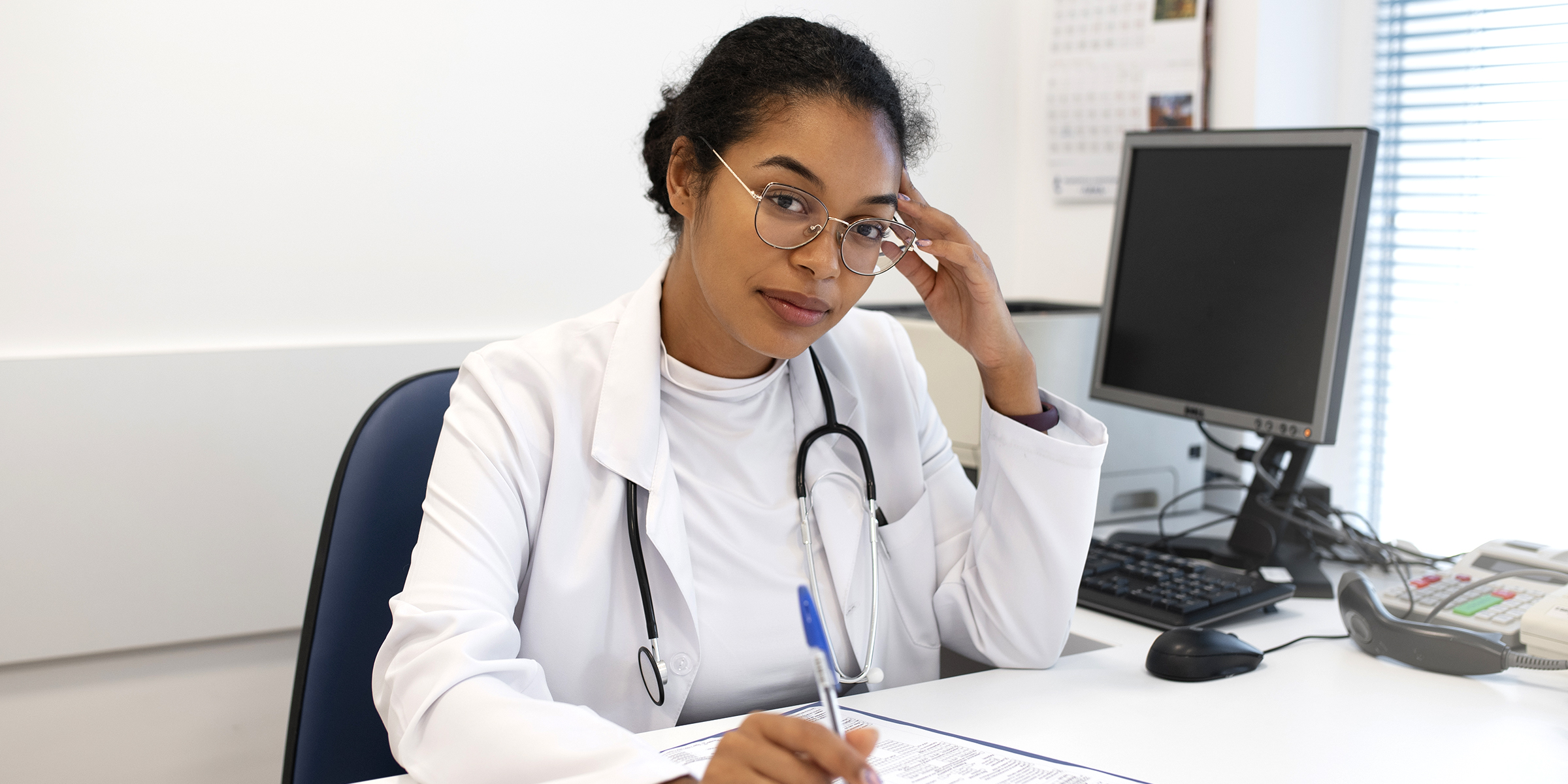 Une médecin assise à son bureau | Source : Freepik