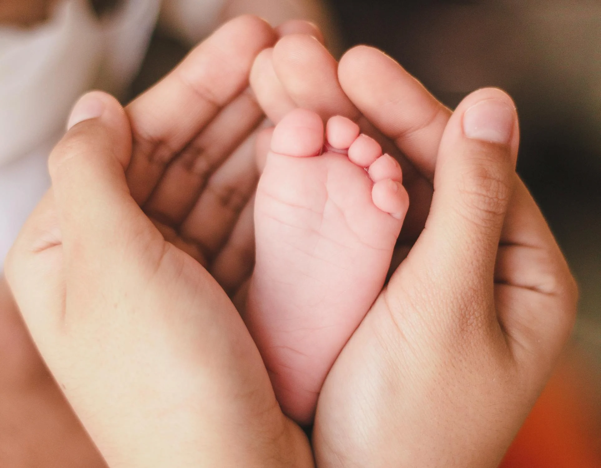 Une femme tenant le pied d'un bébé | Source : Pexels