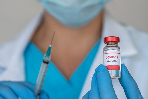 Médecins tenant le vaccin Covid-19 et la seringue. | Photo : Getty Images