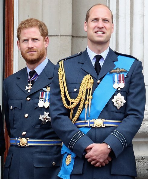 Le prince William, duc de Cambridge et le prince Harry, le duc de Sussex regardent le défilé aérien de la Royal Air Force sur le balcon du palais de Buckingham, alors que des membres de la famille royale assistent à des événements marquant le centenaire de la Royal Air Force le 10 juillet 2018 à Londres, Angleterre | Photo : Getty Images