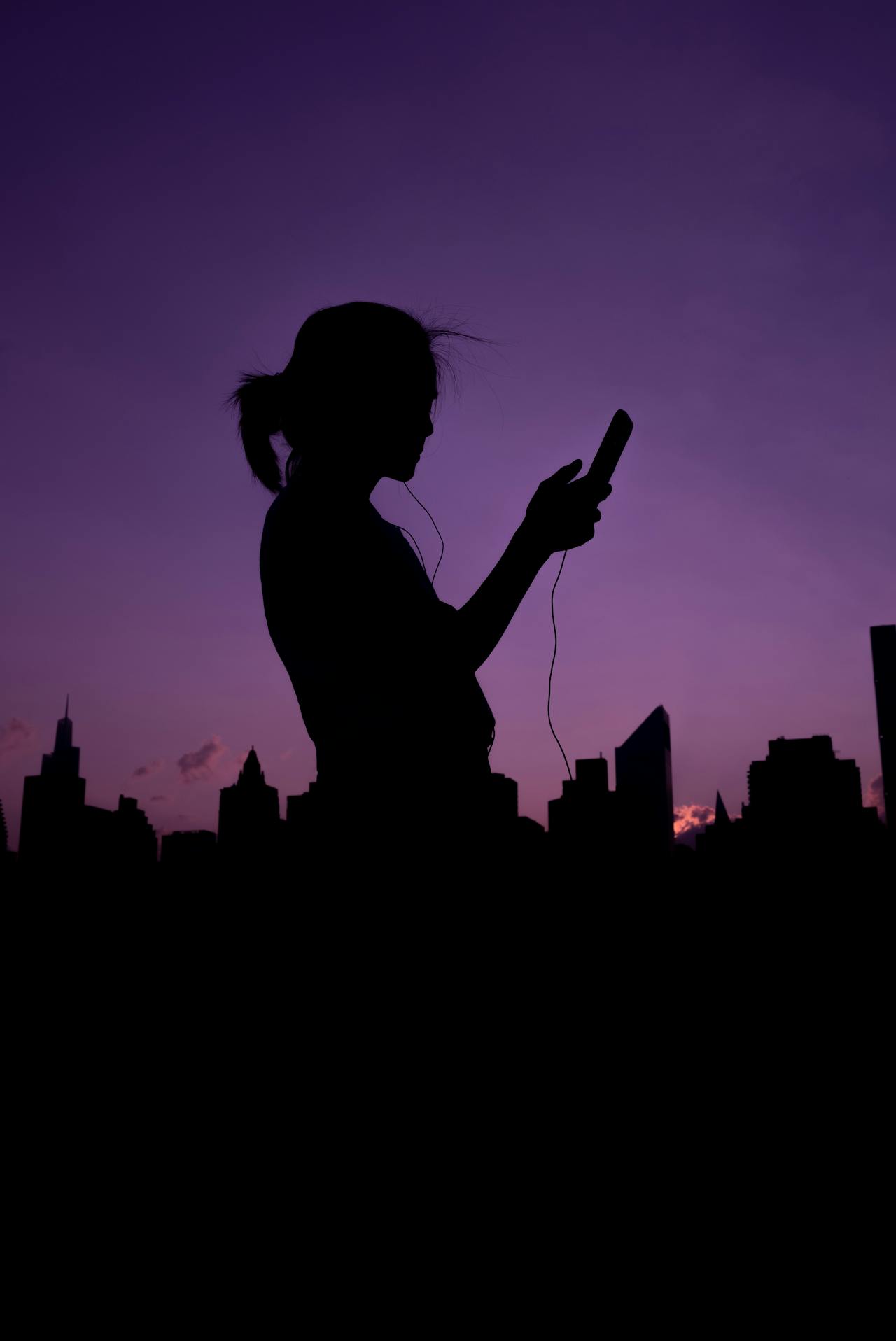 Silhouette d'une femme tenant son téléphone | Source : Pexels