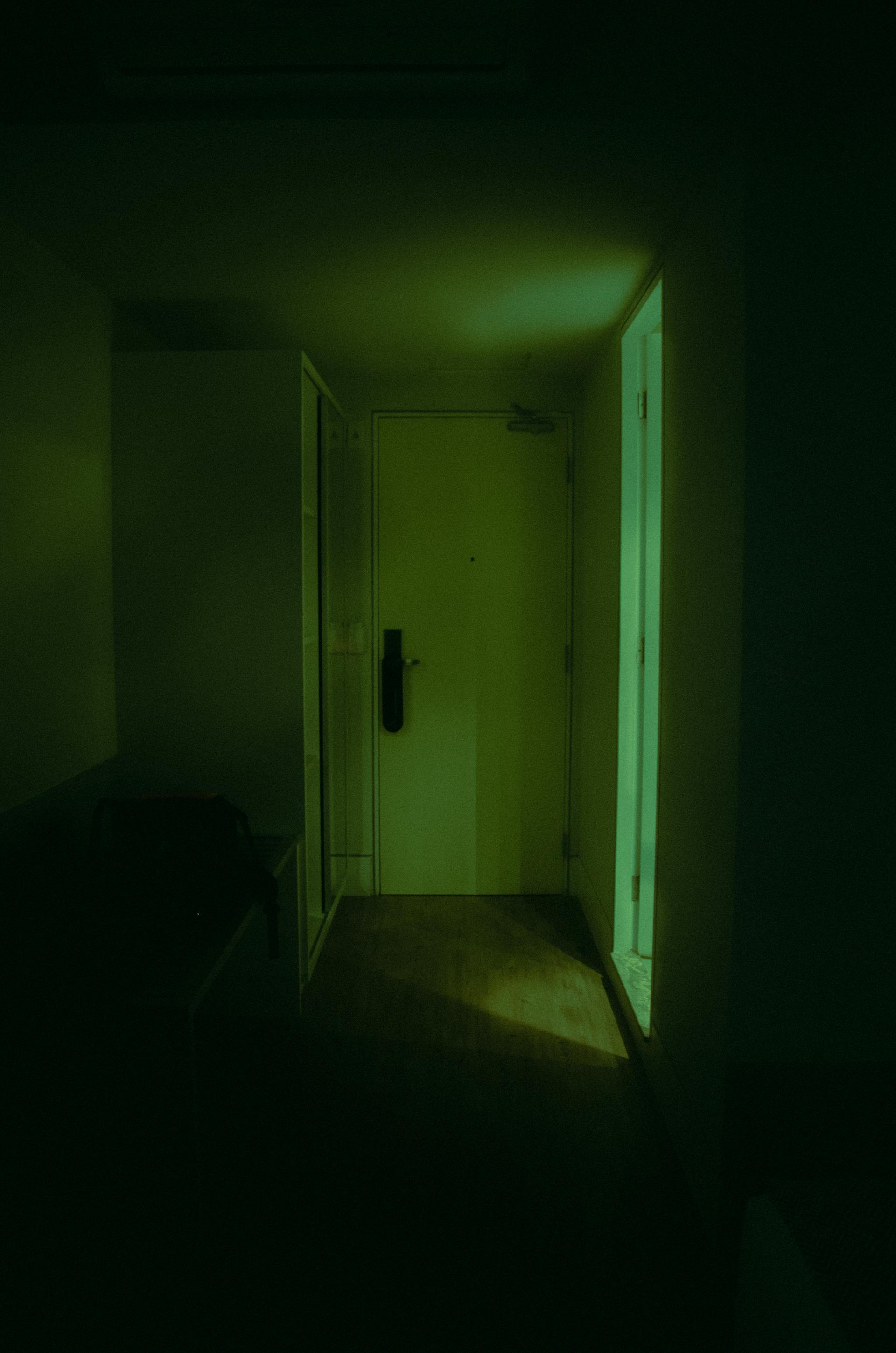 Une porte fermée au bout d'un couloir peu éclairé | Source : Pexels