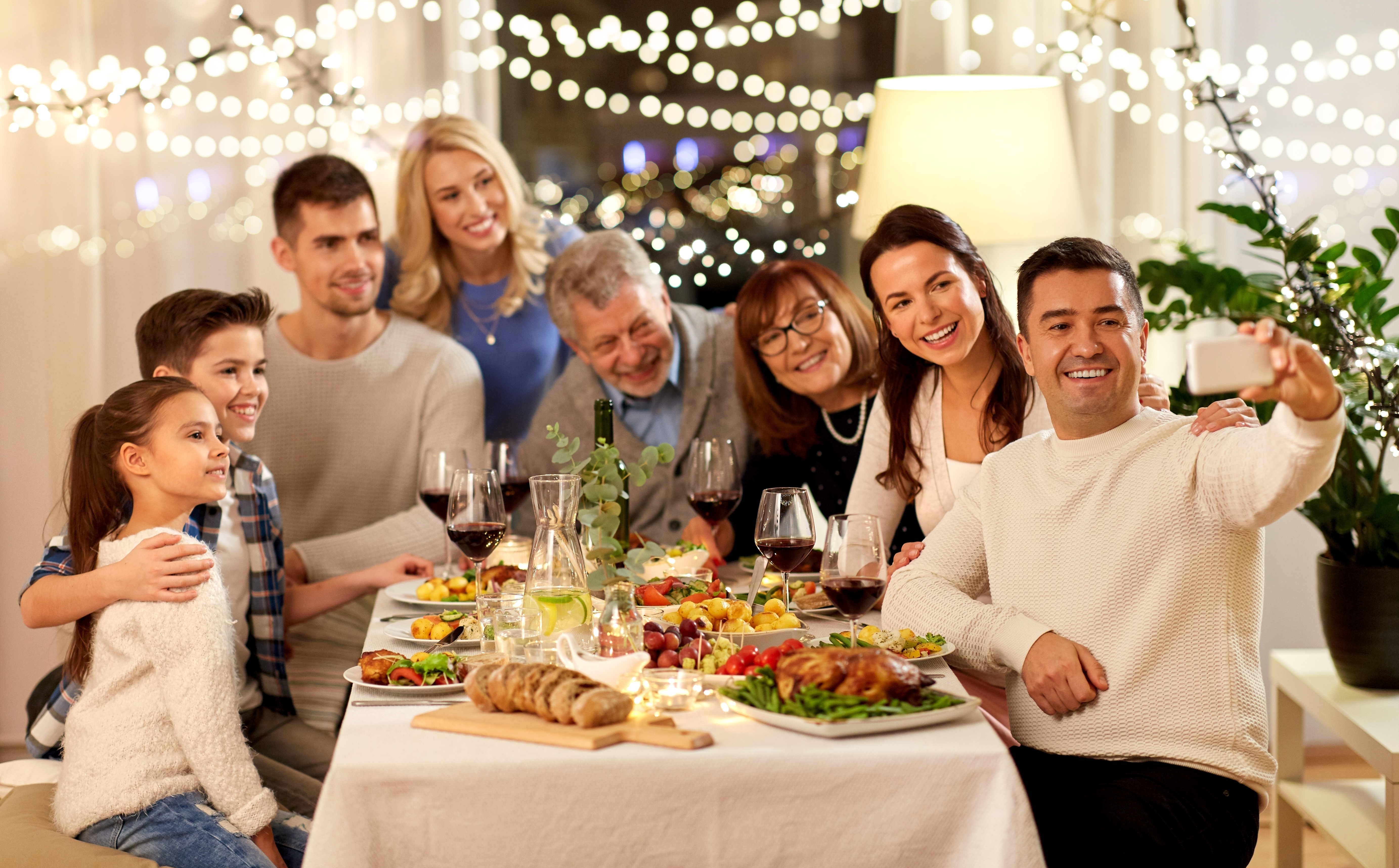Un homme qui clique sur un selfie lors d'un dîner en famille | Source : Shutterstock