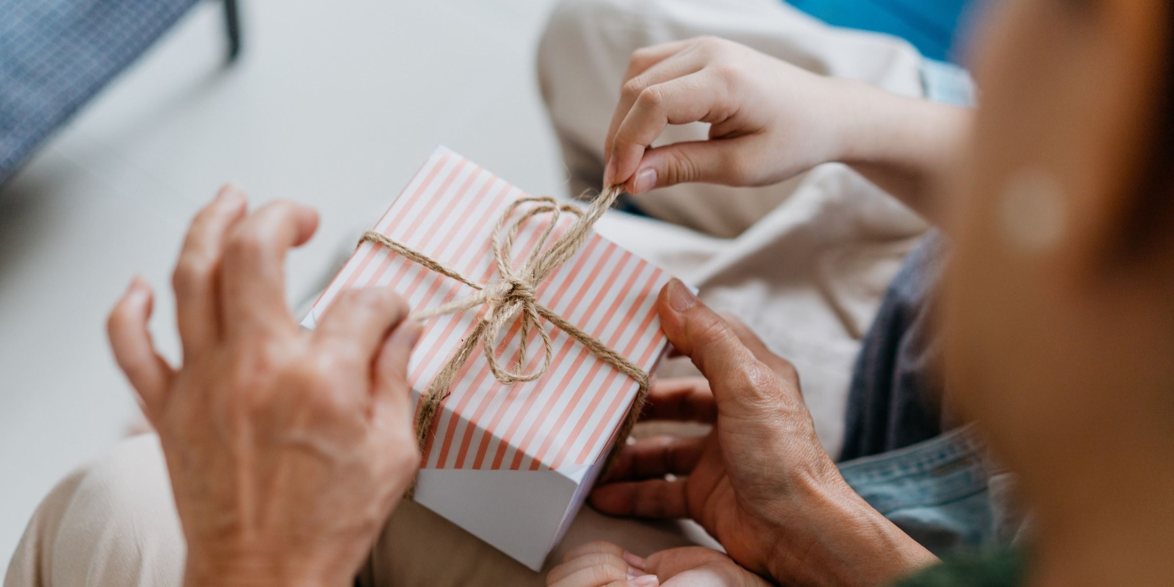 Une grand-mère et son petit-enfant en train d'ouvrir un paquet cadeau | Source : Getty Images