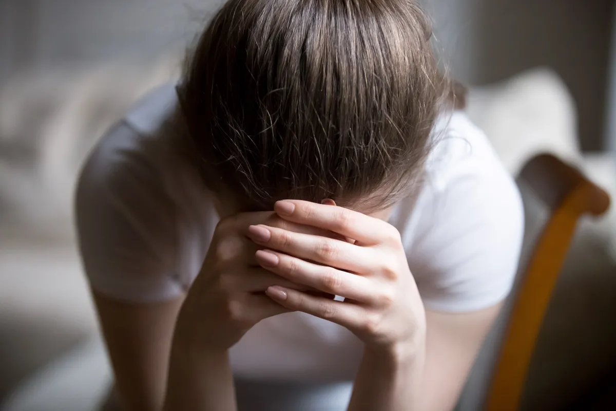 Une jeune femme déprimée qui pleure chez elle | Source : Shutterstock