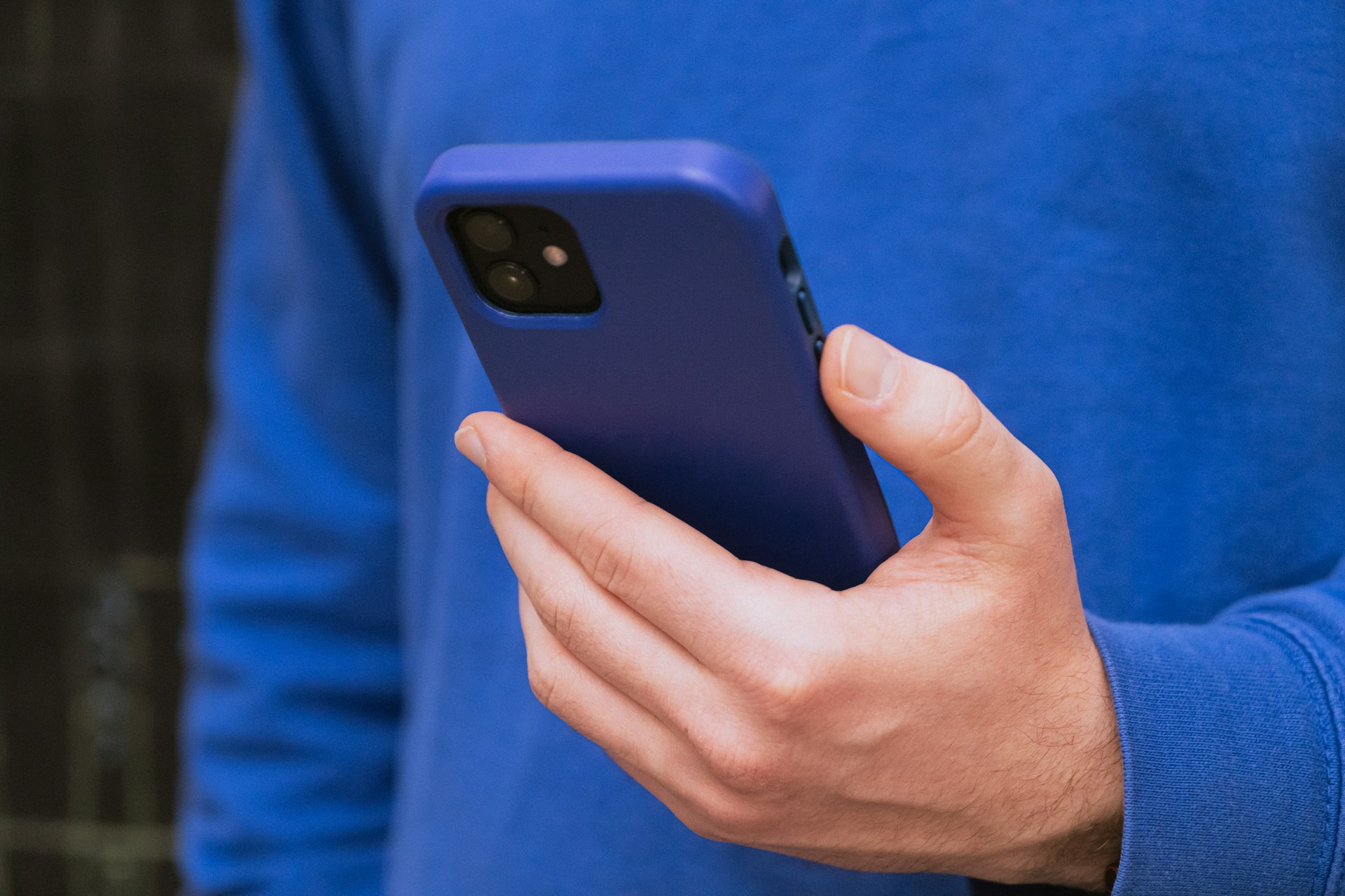 Photo recadrée d'un homme tenant son téléphone | Source : Unsplash