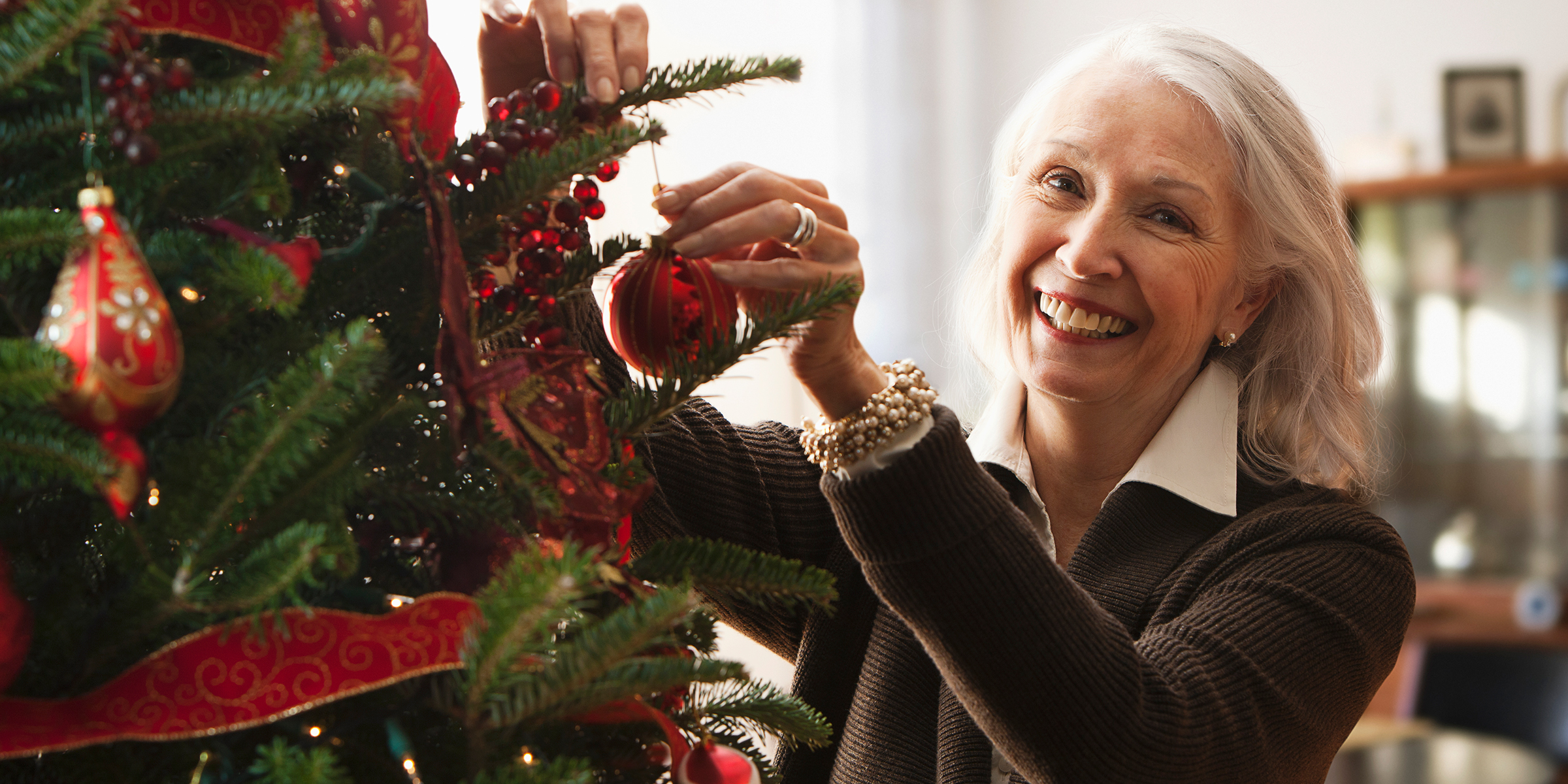 Une femme décorant un arbre de Noël | Source : Getty Images
