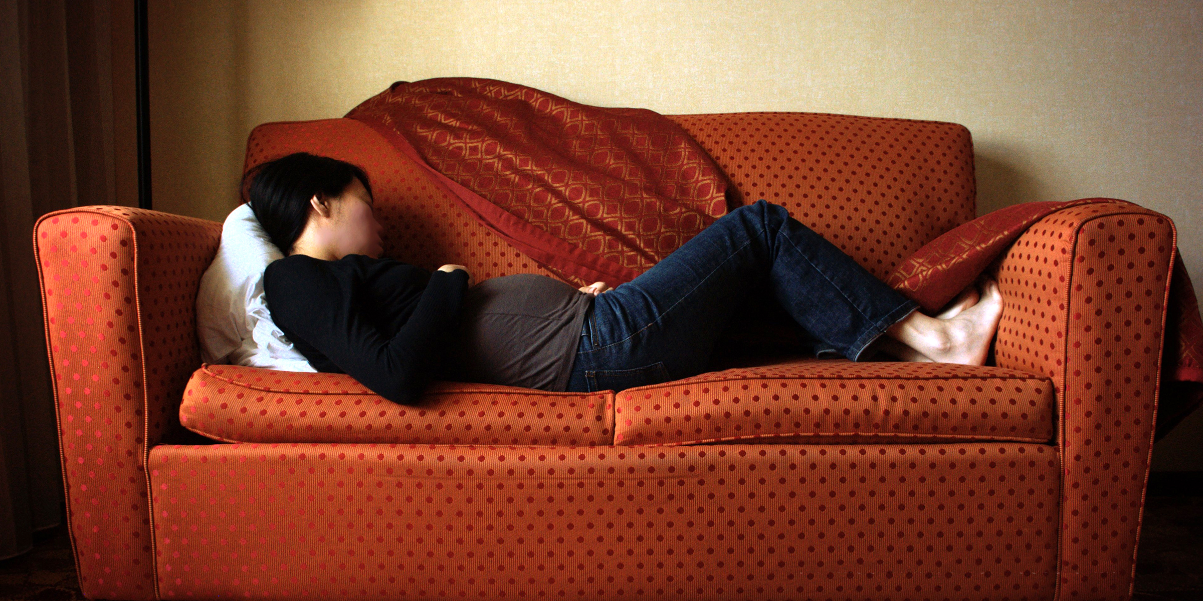 Une femme enceinte endormie sur le canapé | Source : Flickr.com/photos/koadmunkee/