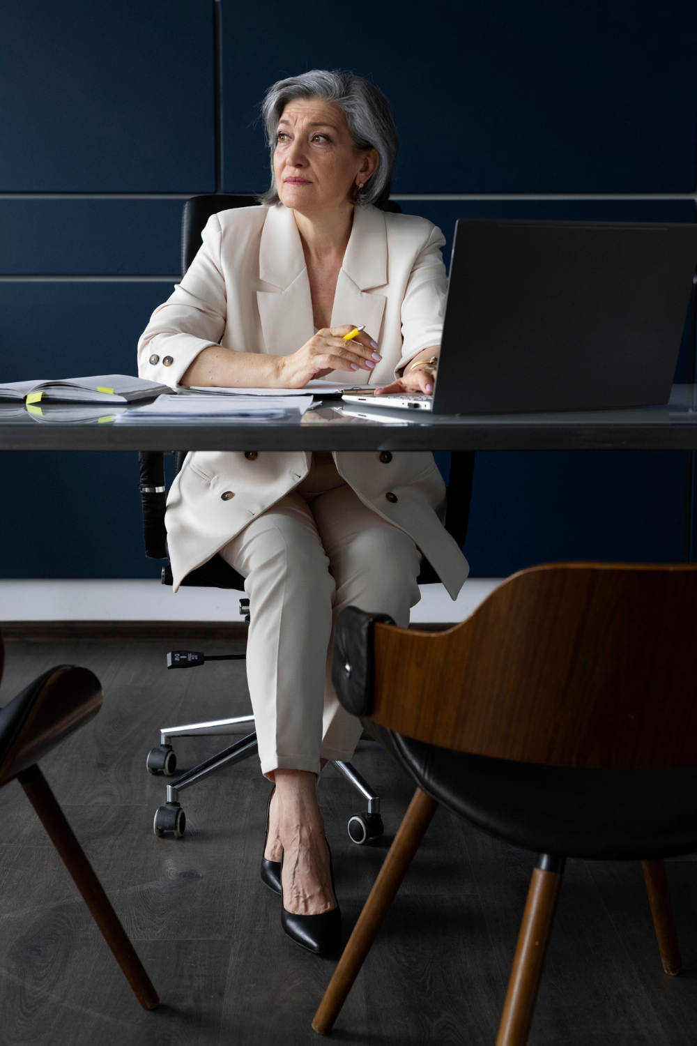 Une femme âgée assise dans son bureau | Source : Freepik