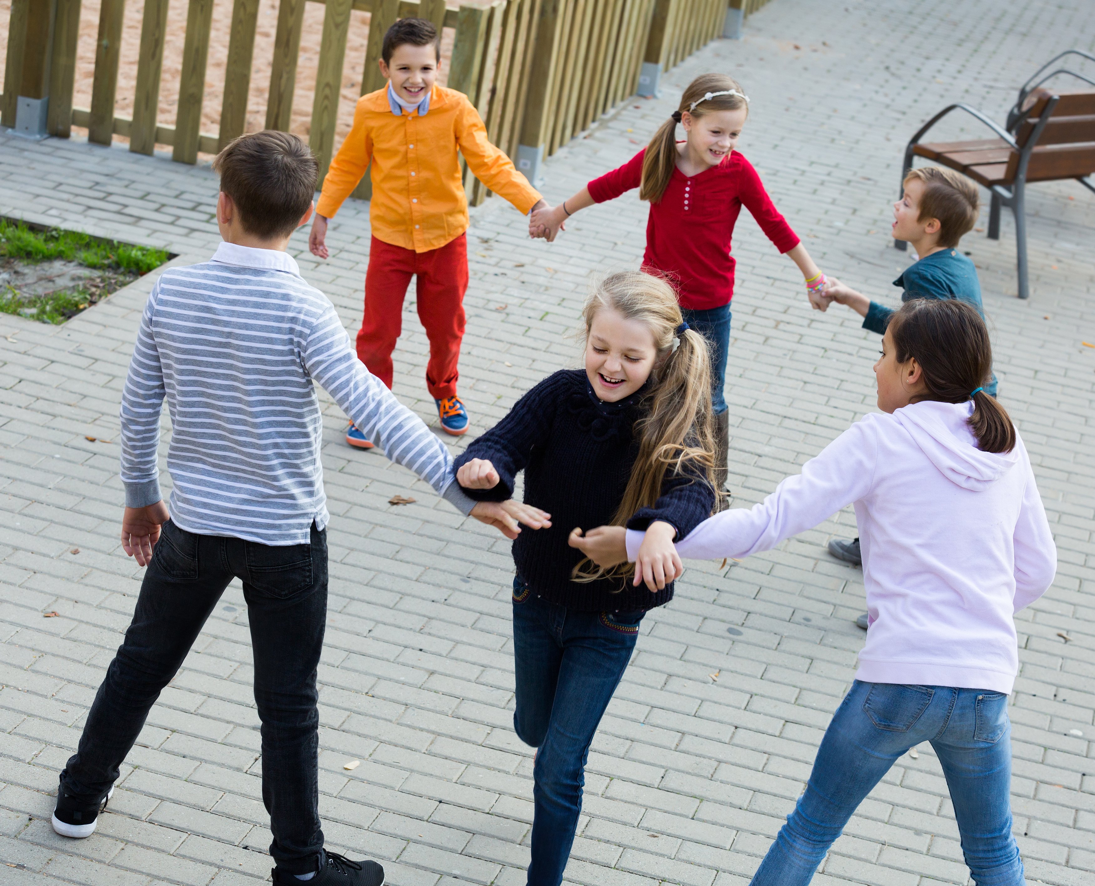 Groupe d'enfants heureux jouant du rover rouge à l'extérieur | Photo : Shutterstock