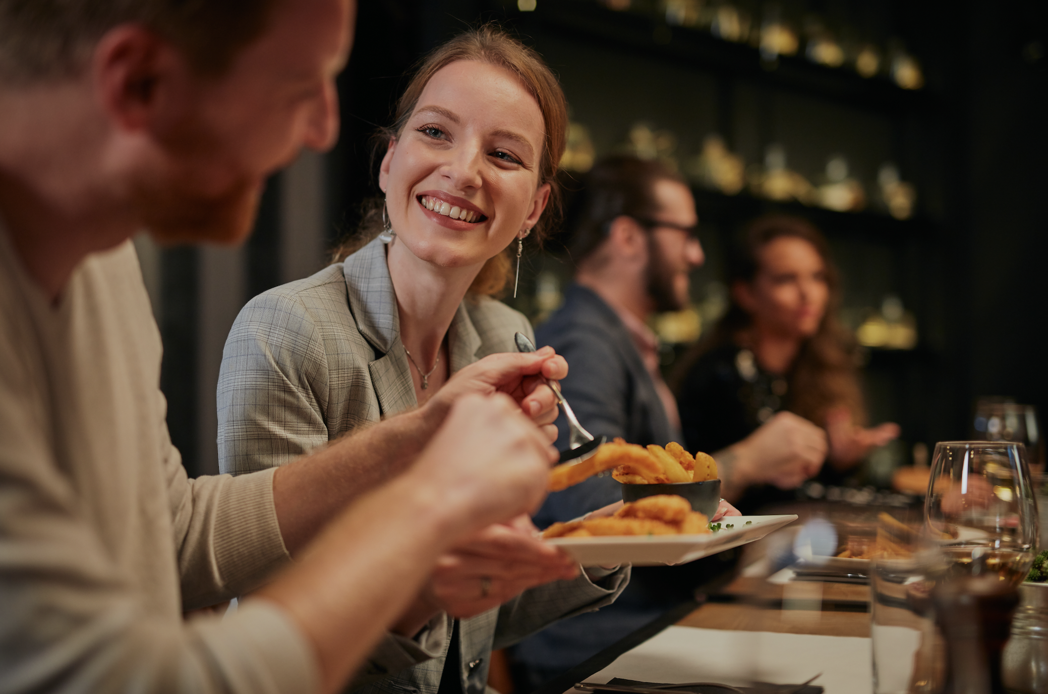 Une jeune femme sourit à l'homme dans le restaurant | Source : Shutterstock