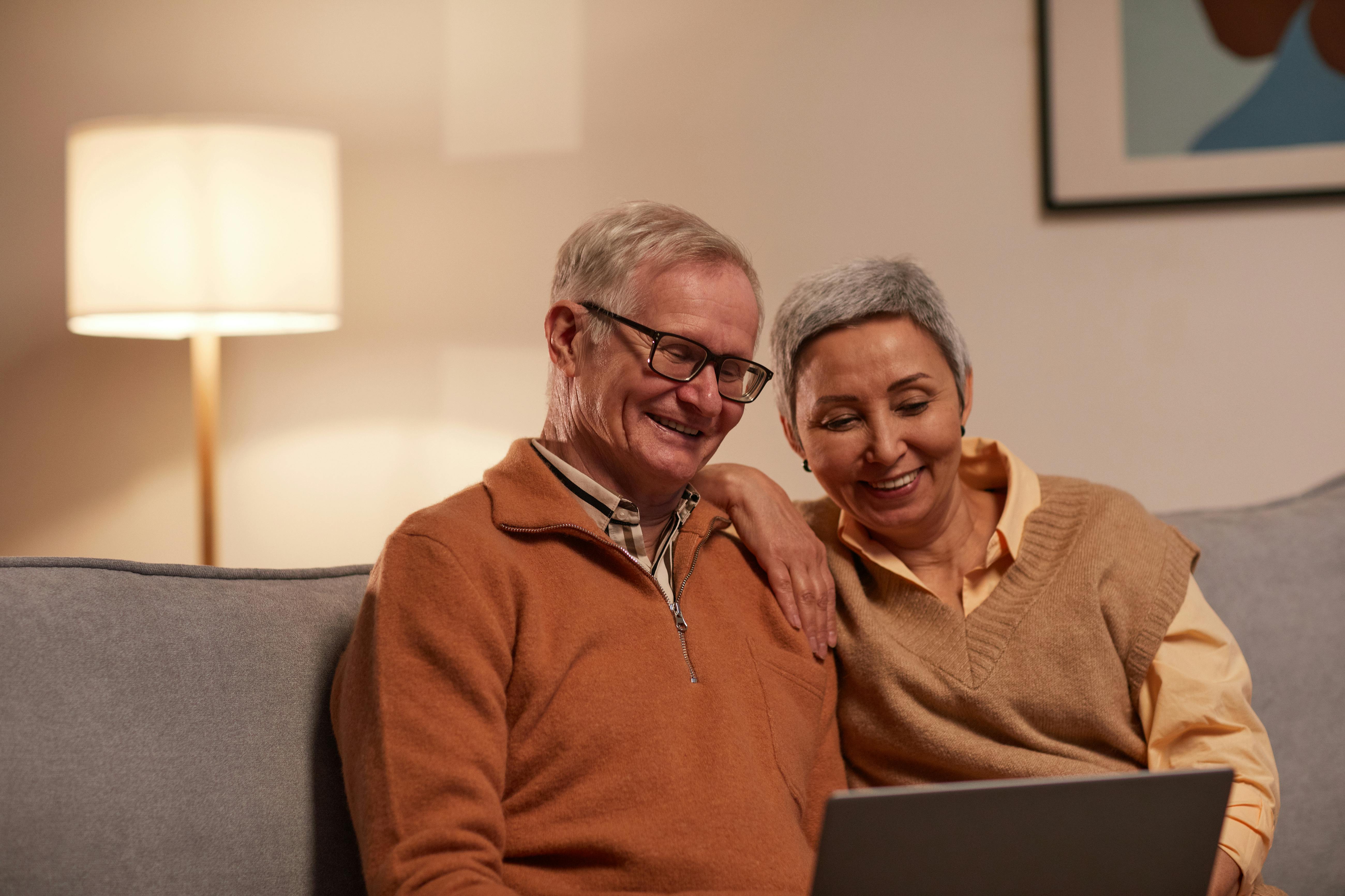 Un couple heureux qui regarde quelque chose sur un ordinateur portable | Source : Pexels