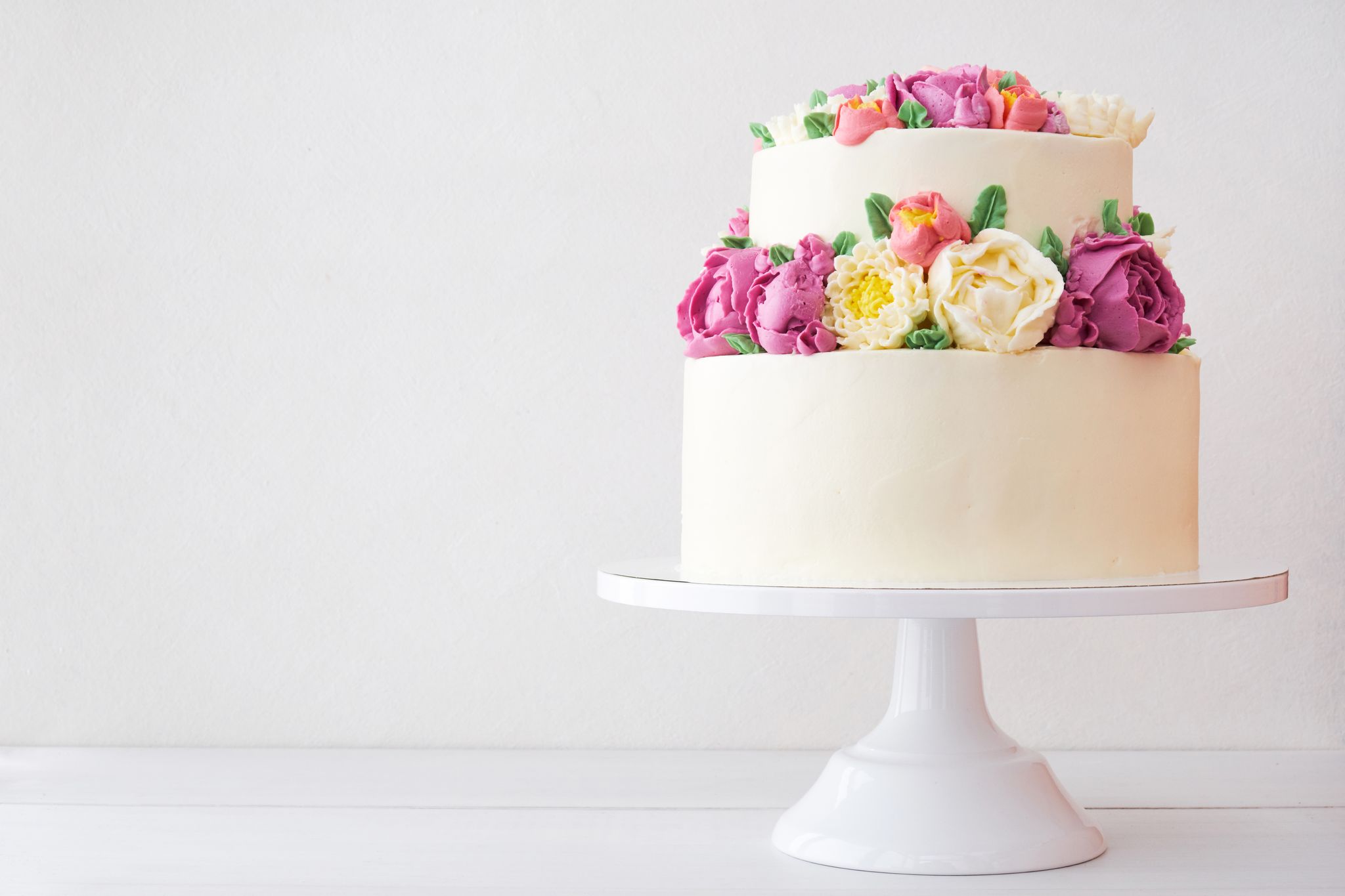 Un gâteau blanc à deux étages avec des décorations florales. | Source : Getty Images