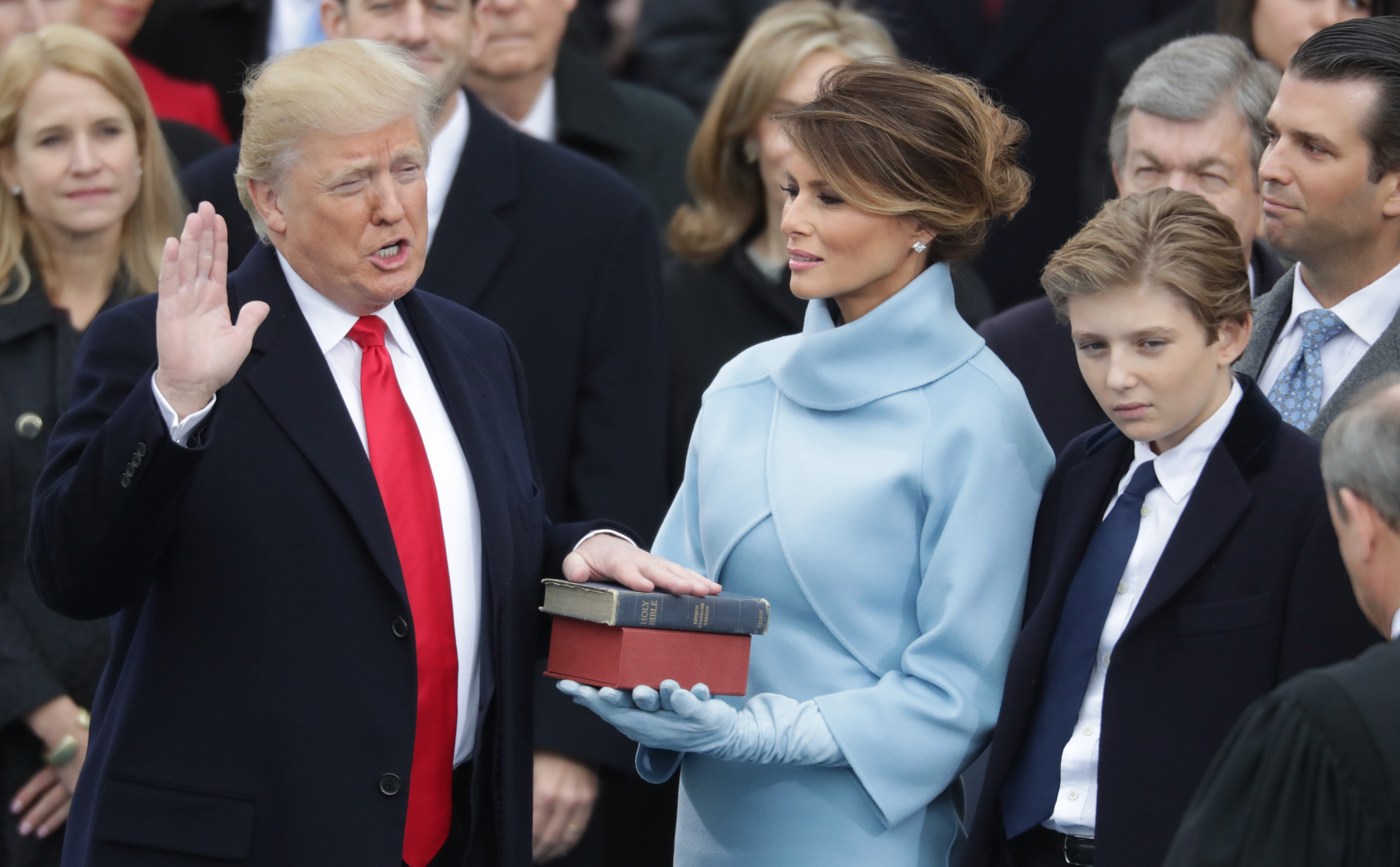 Donald Trump prête serment sous le regard de Melania Trump qui tient la bible et de Barron Trump, sur le front ouest du Capitole américain à Washington, DC, le 20 janvier 2017 | Source : Getty Images