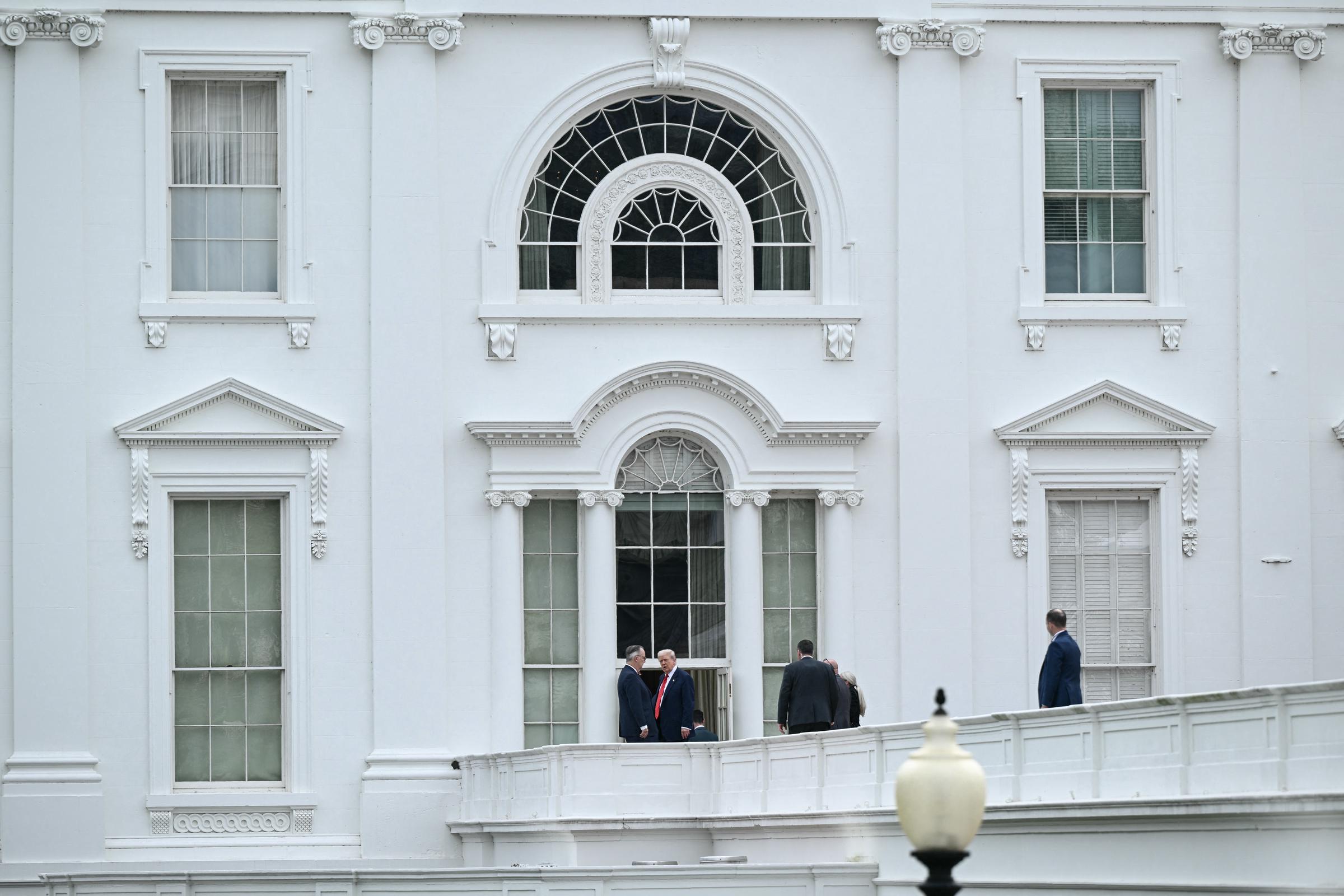Le président Donald Trump arpente le terrain de la Maison-Blanche depuis le toit de l'aile ouest à Washington, le 5 août 2025, alors que le personnel de sécurité l'accompagne lors de ce qui semble être une inspection improvisée.