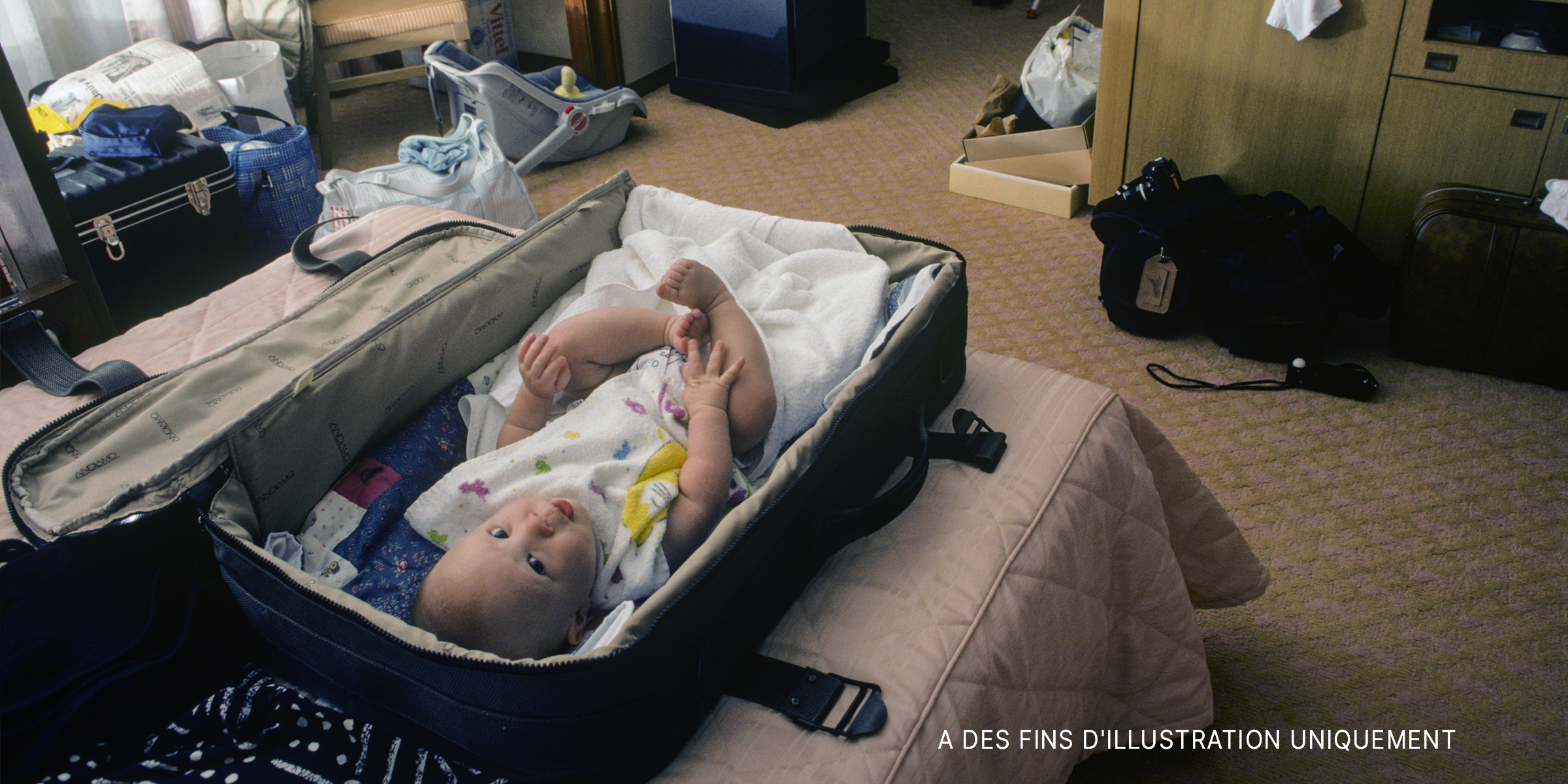 Bébé couché dans une valise | Source : Shutterstock
