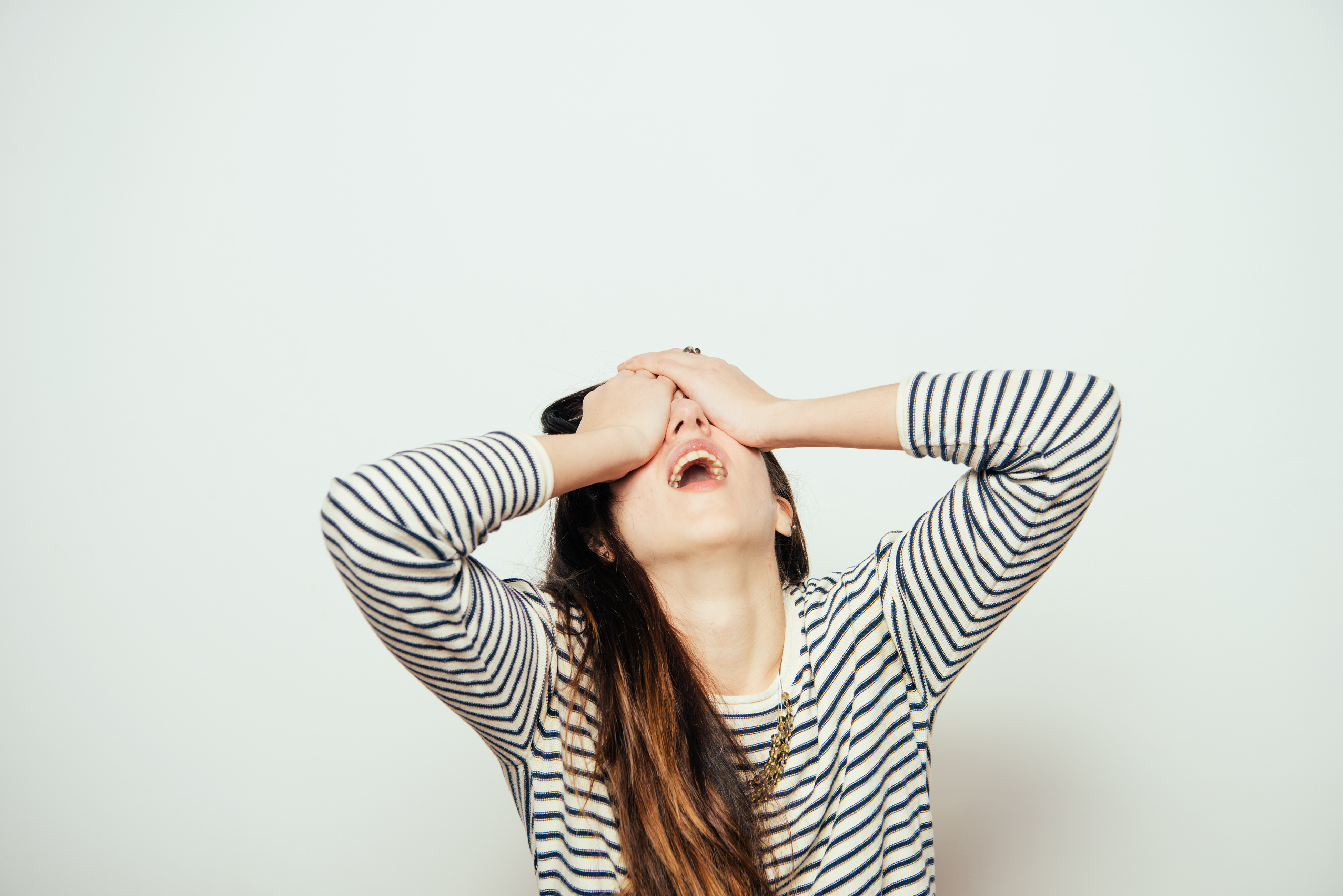 Femme exaspérée se tenant les yeux fermés | Source : Shutterstock