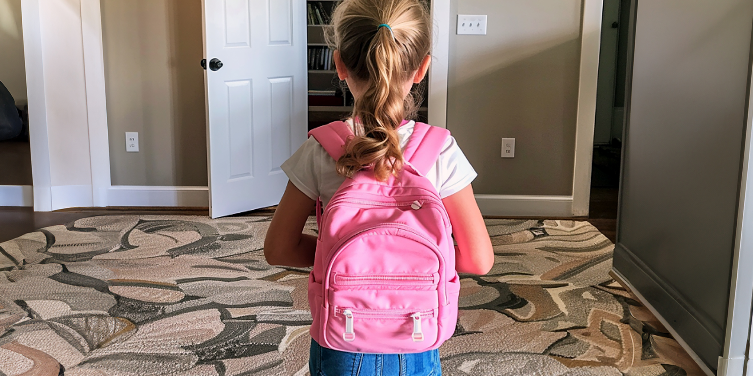 Une petite fille avec un sac à dos rose | Source : Midjourney