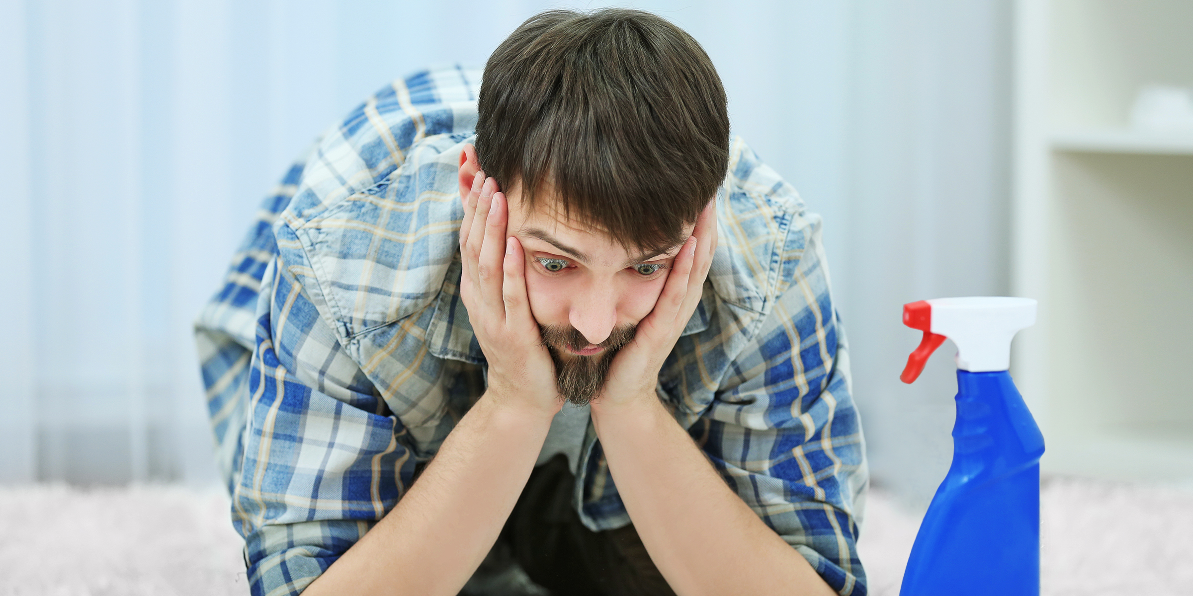 Un homme confus voyant une bouteille de nettoyant | Source : Shutterstock