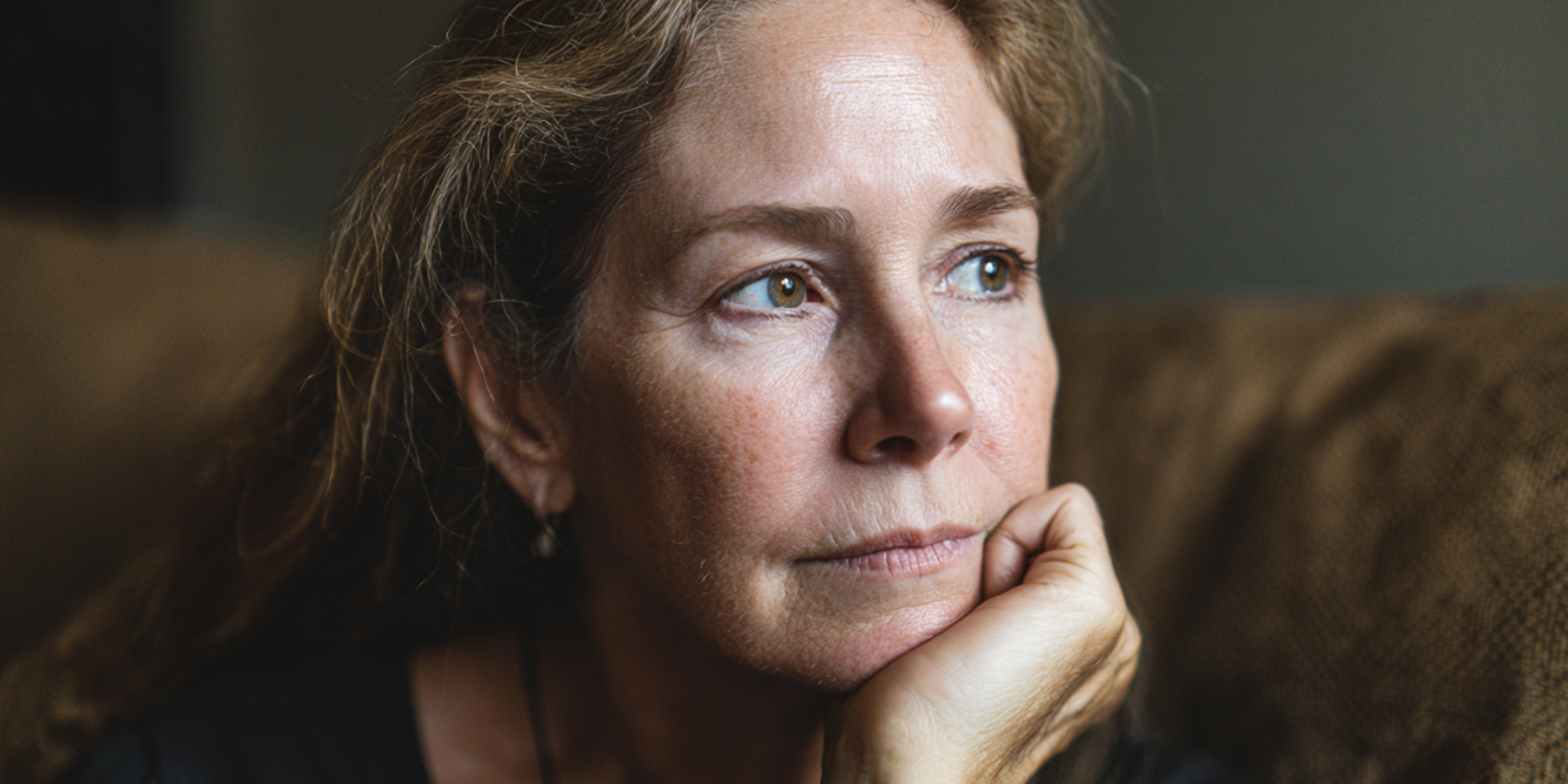 Une femme assise et regardant fixement avec une expression distante et peinée | Souce : The Celebritist