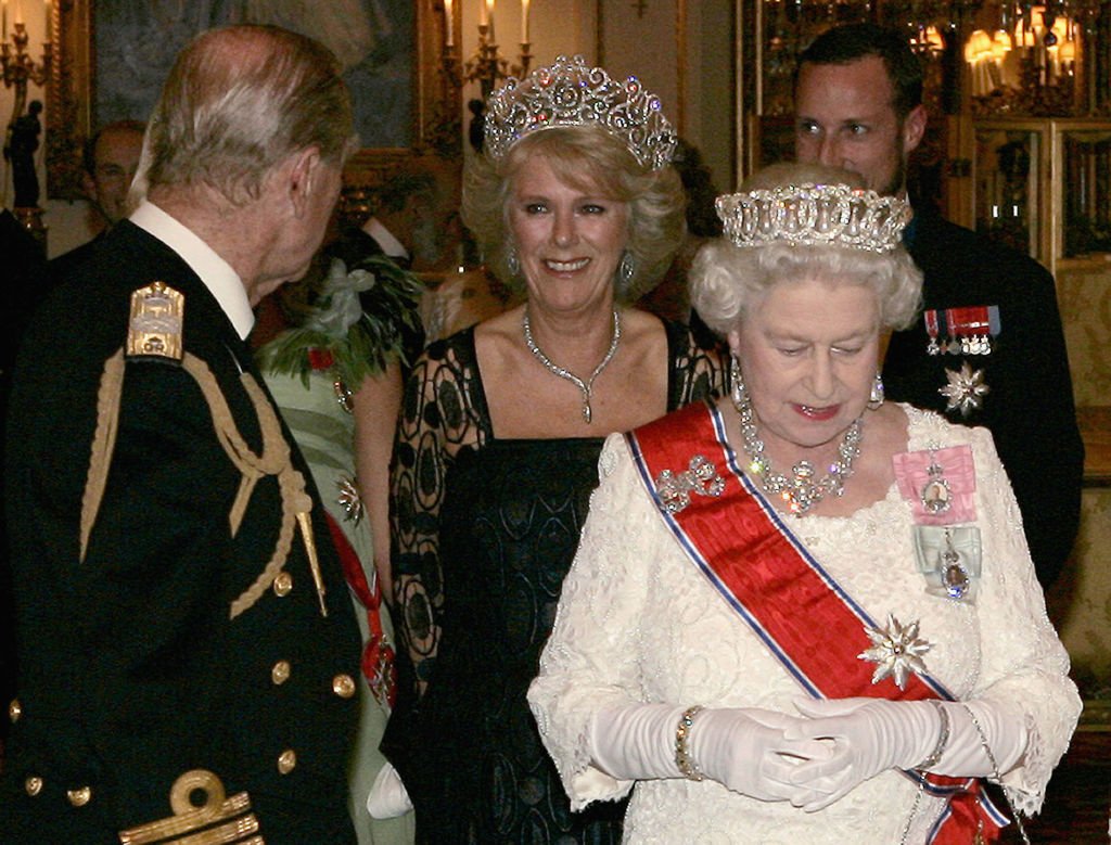 Camilla, duchesse de Cornouailles, portant un héritage royal composé d'une tiare, d'un collier et de boucles d'oreilles en diamants, assiste à un banquet au palais de Buckingham avec le prince Philip, duc d'Édimbourg, la reine Élisabeth II et le prince héritier Haakon de Norvège, le 25 octobre 2005 à Londres. | Photo : Getty Images