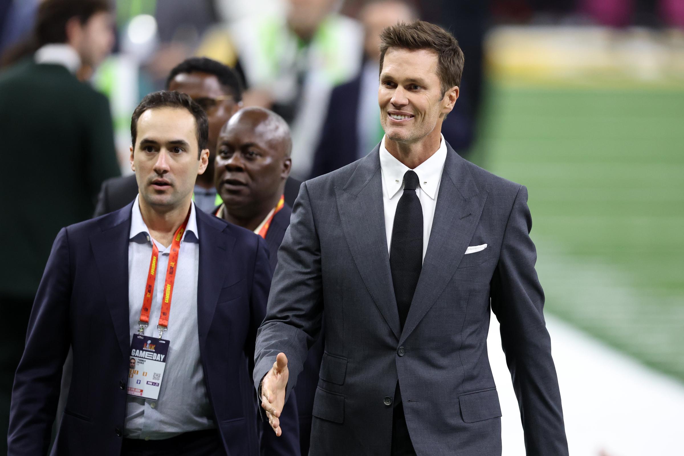 Tom Brady traverse le terrain avec des gens lors du Super Bowl. | Source : Getty Images