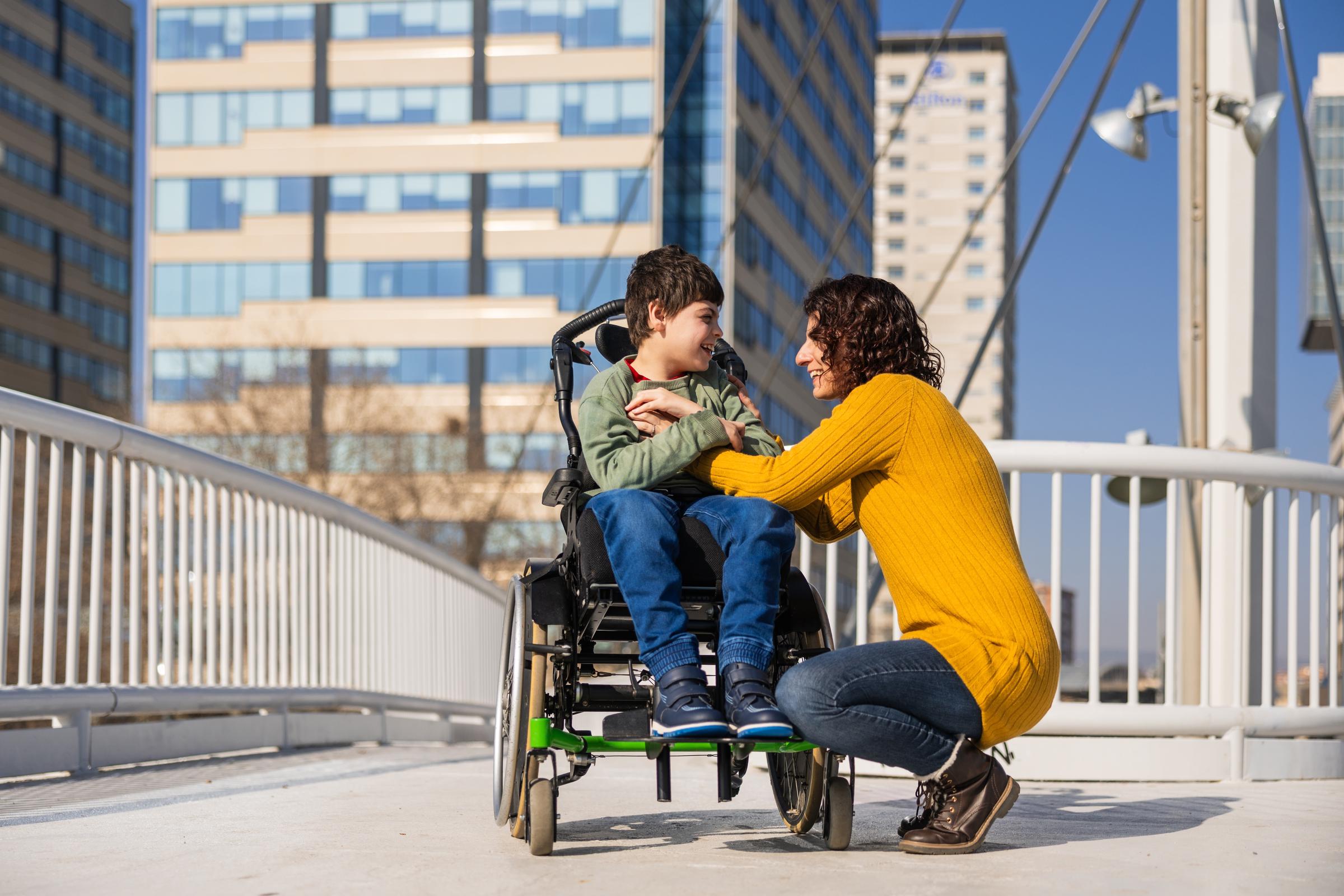 Une femme assise à côté de son fils en fauteuil roulant | Source : Shutterstock