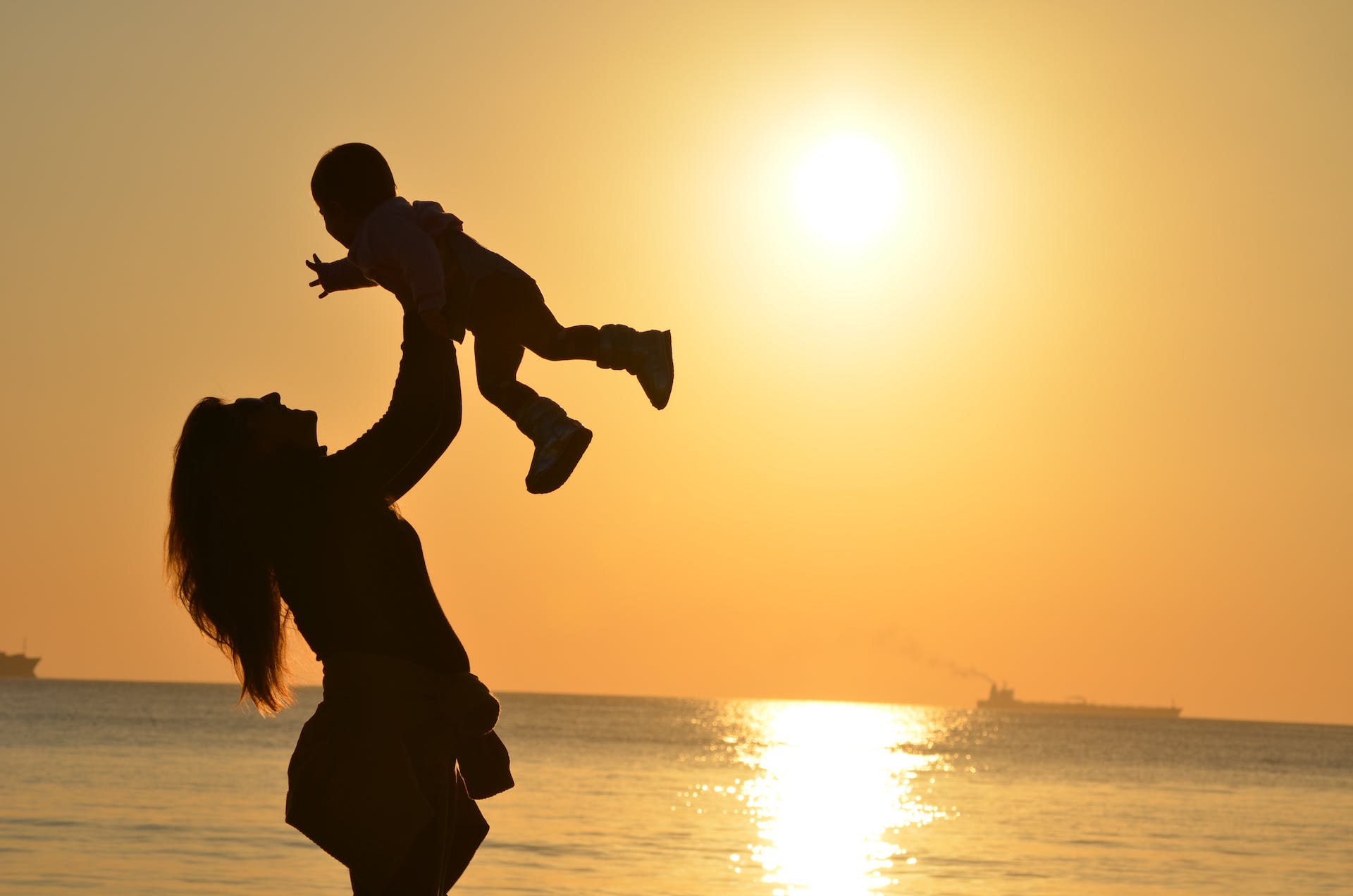 Silhouette d'une mère portant son bébé à la plage | Source : Pexels