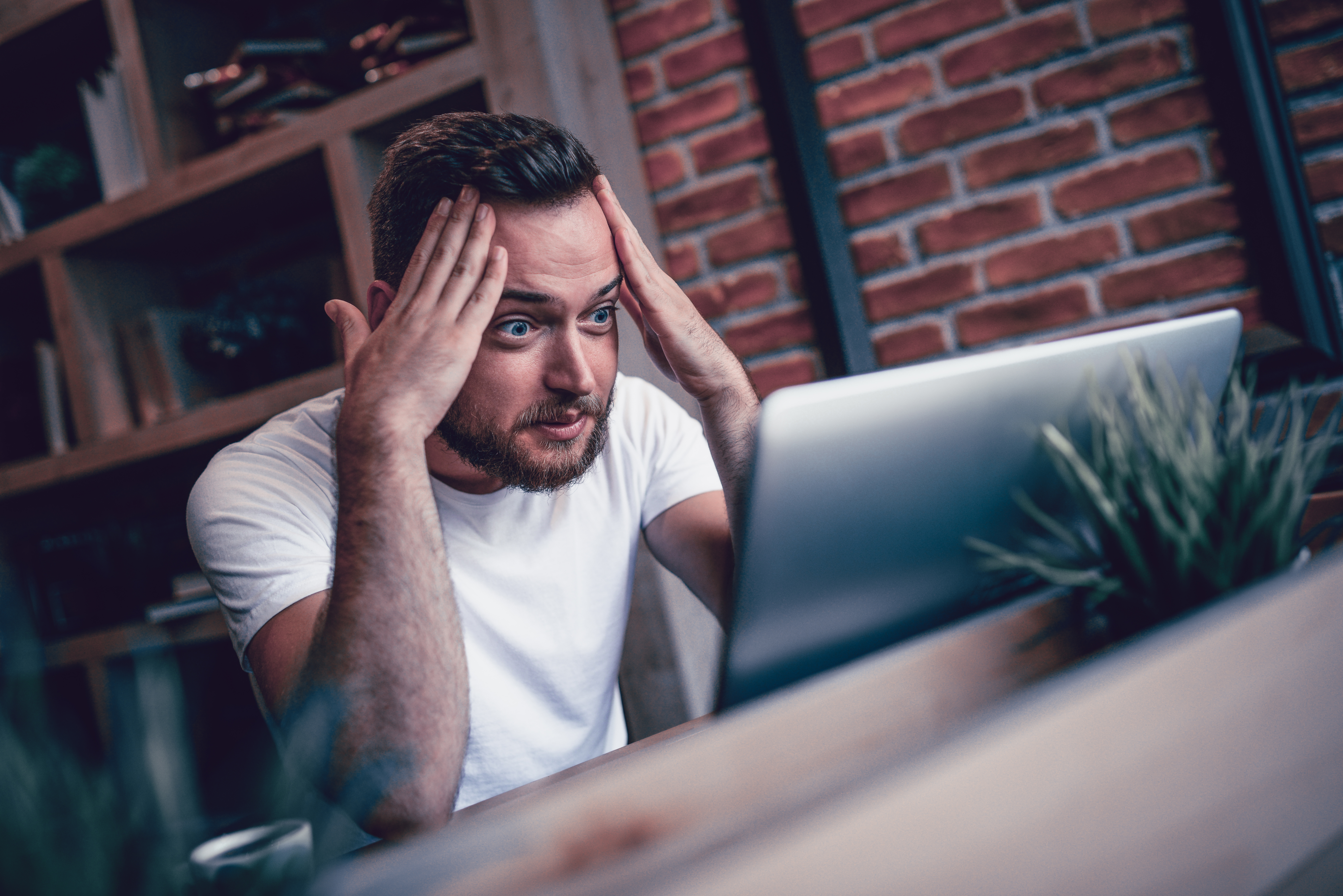 Freelance choqué et incrédule travaillant à son café préféré | Source : Getty Images