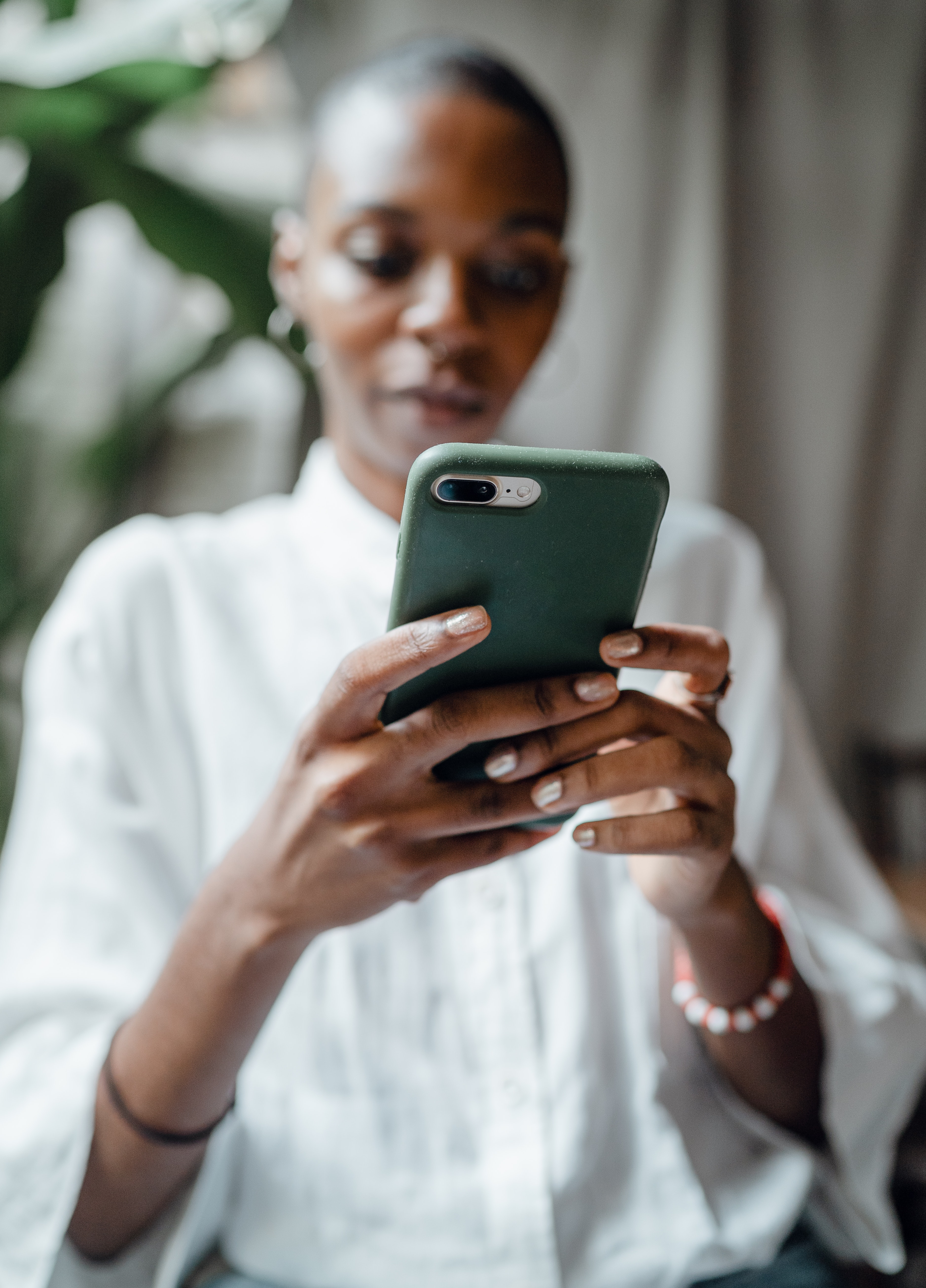 Femme noire lisant des messages sur son téléphone | Source : Pexels