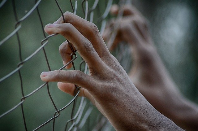 Les mains s'accrochent à la clôture. | Source : PixaBay