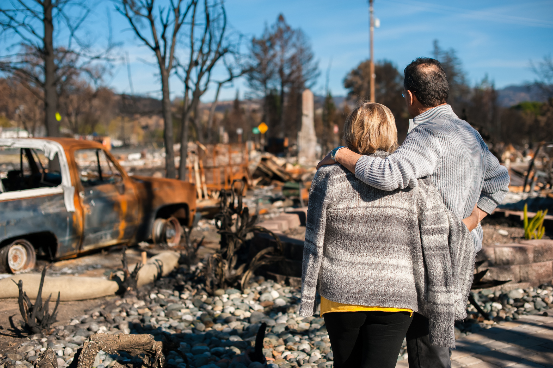 Un couple regarde la maison brûlée | Source : Getty Images