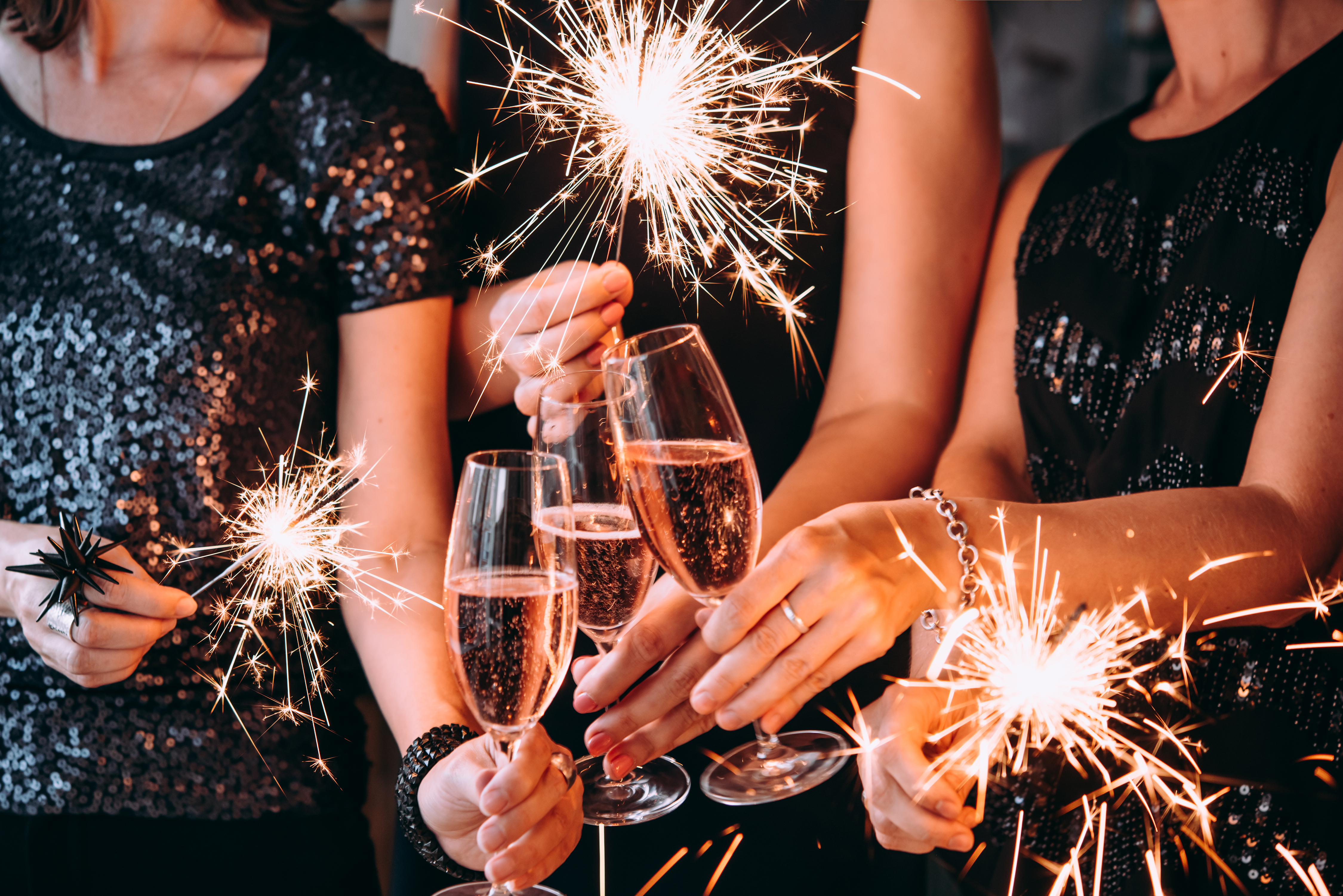 Un groupe d'amis fêtant le nouvel an avec des feux de Bengale et du champagne rosé | Source : Shutterstock