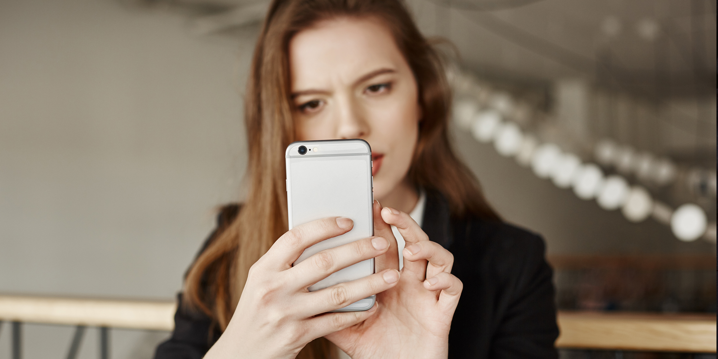 Une femme fronce les sourcils devant son téléphone | Source : Freepik