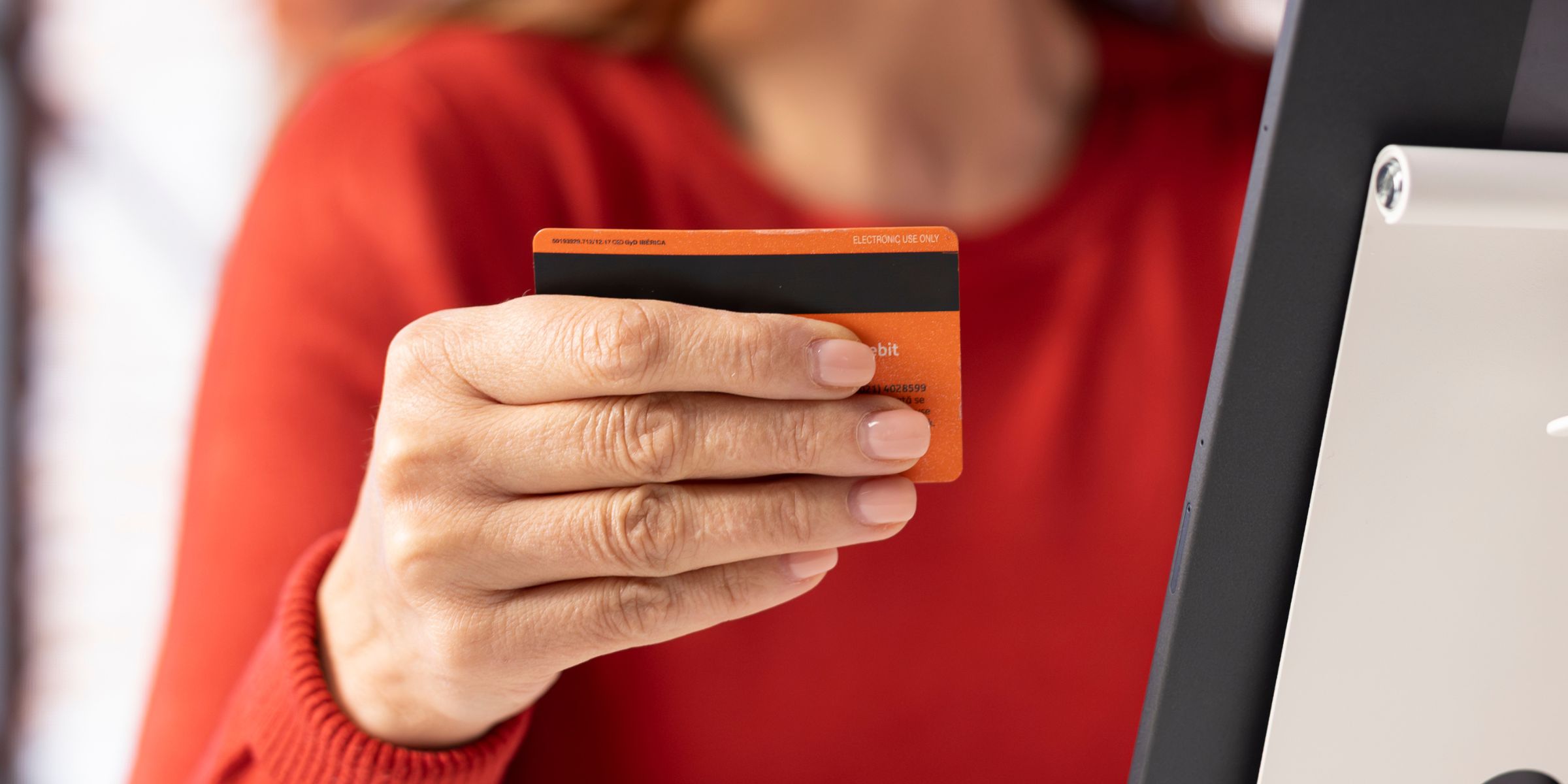 Une femme tenant une carte de crédit | Source : Freepik