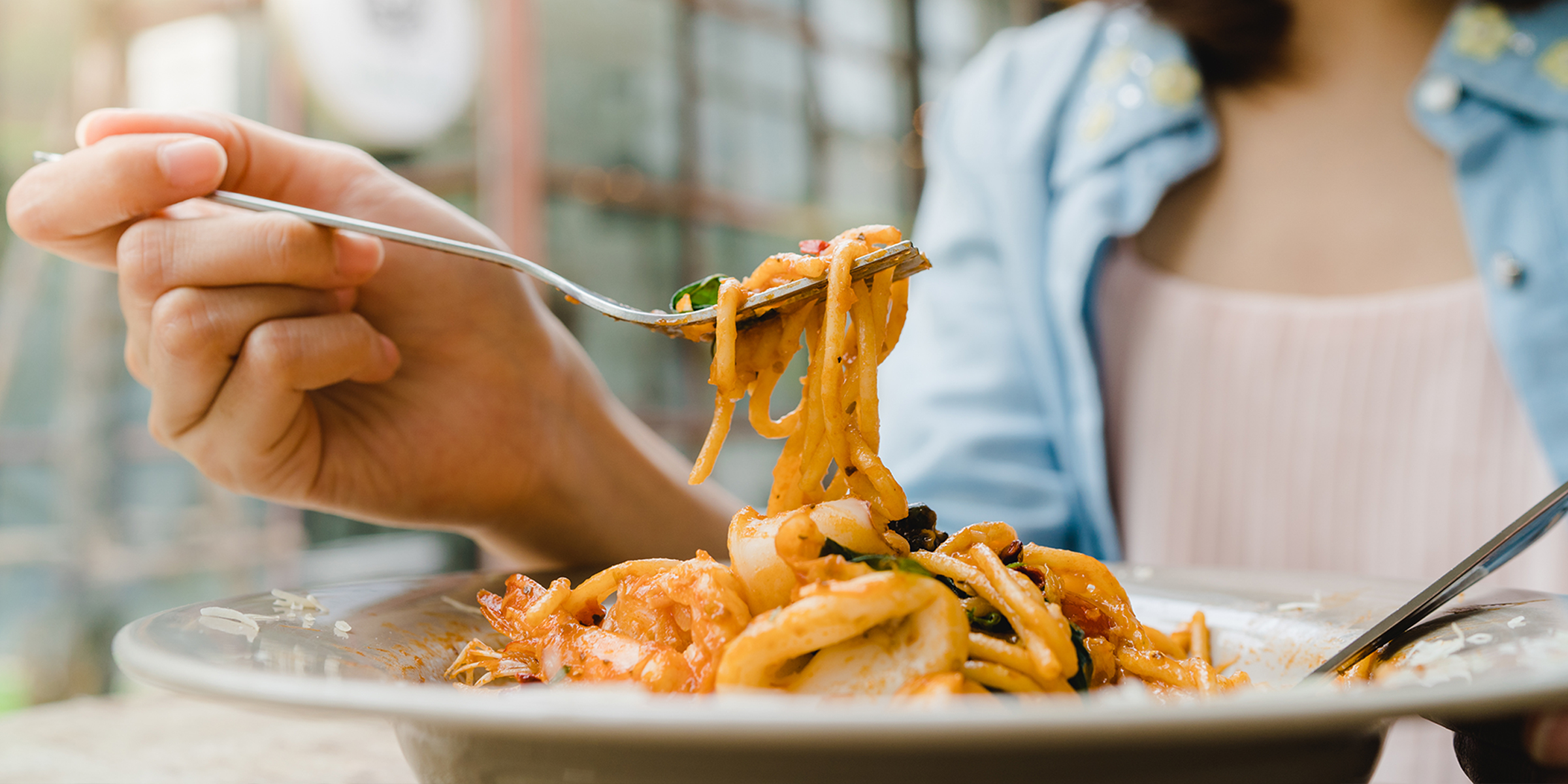 Gros plan d'une femme qui mange des pâtes | Source : Shutterstock