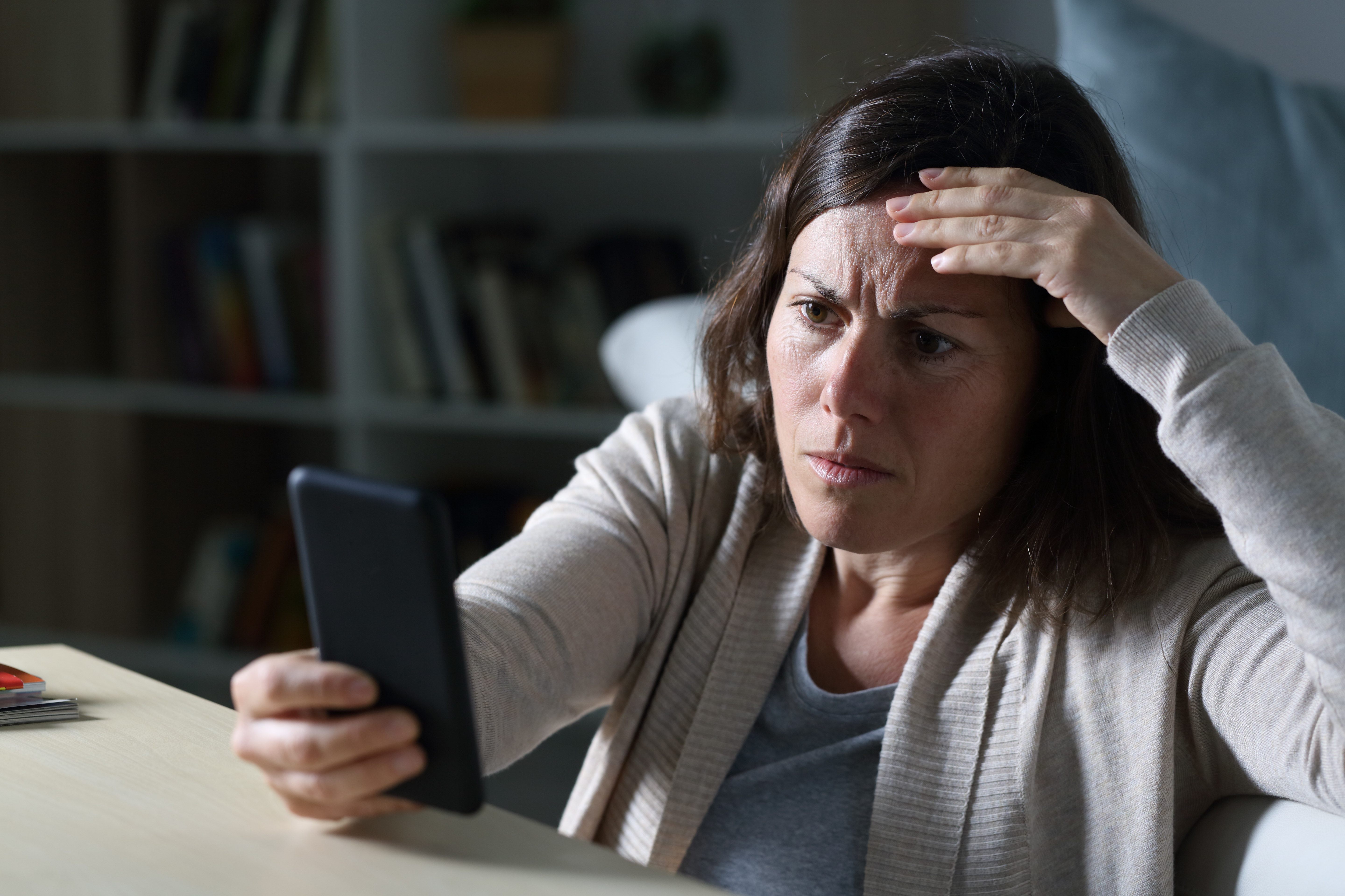 Une femme à l'air inquiet tout en regardant un téléphone | Source : Shutterstock