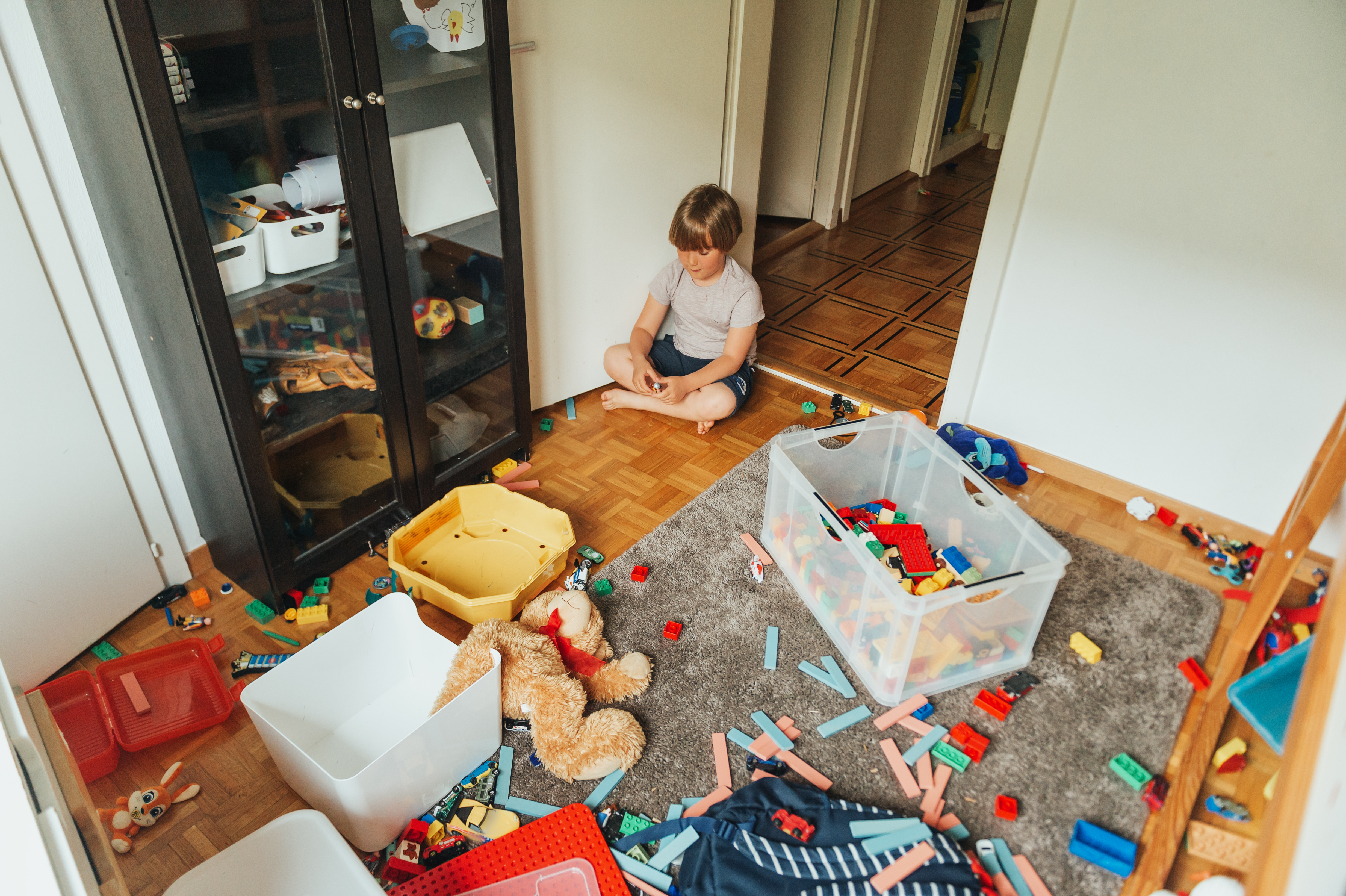 Un enfant assis dans une pièce en désordre | Source : Shutterstock
