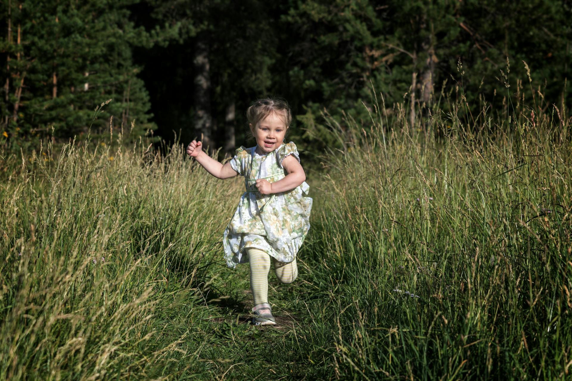 Une petite fille qui court sur l'herbe | Source : Pexels