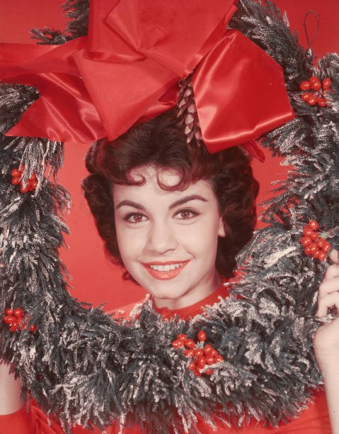 Annette Funicello, posant avec sa tête entourée d'une couronne de Noël décorative, vers 1955. | Source : Getty Images