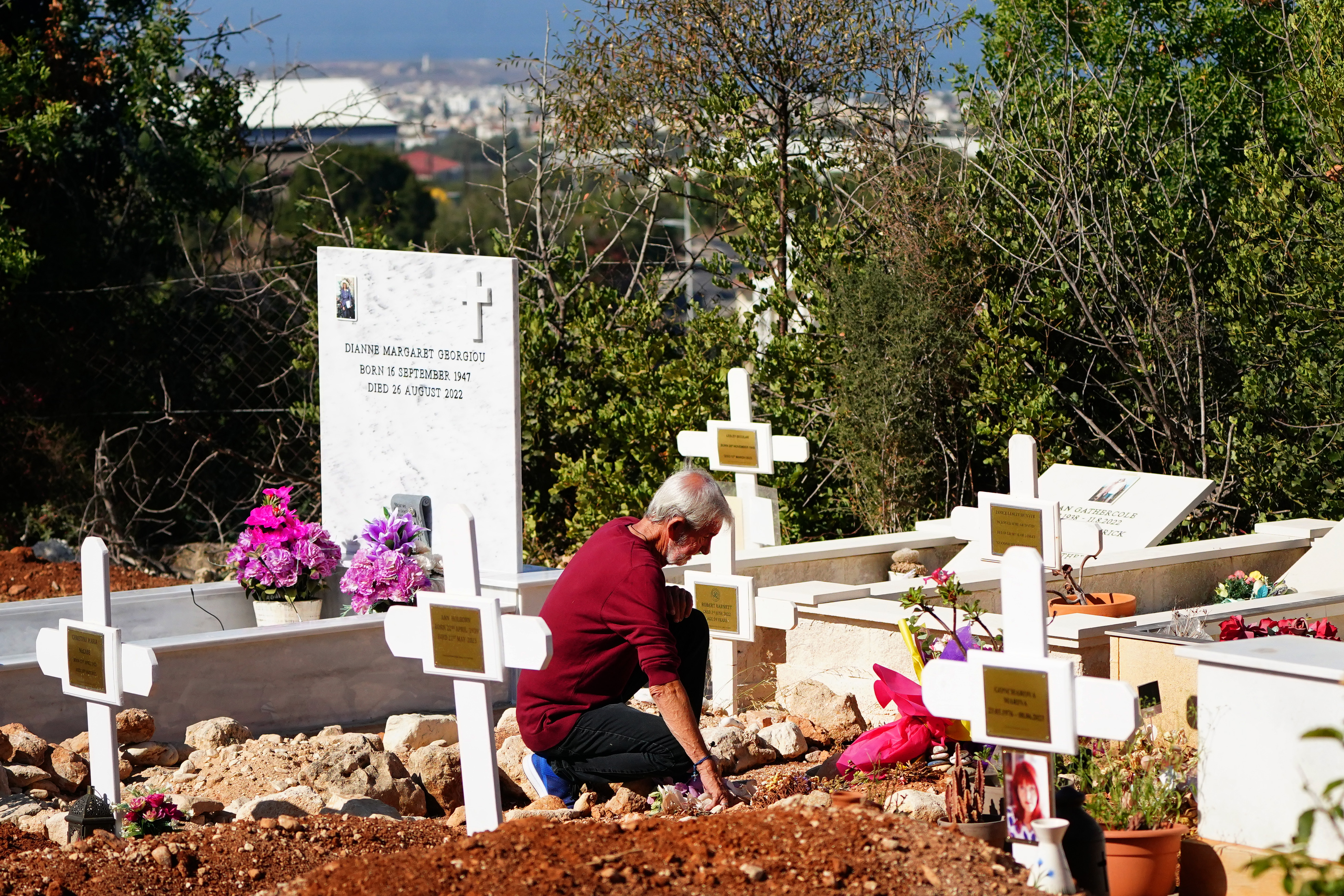 David Hunter s'agenouille devant la tombe de sa femme dans un cimetière à Paphos, Chypre, le 1er août 2023 | Source : Getty Images