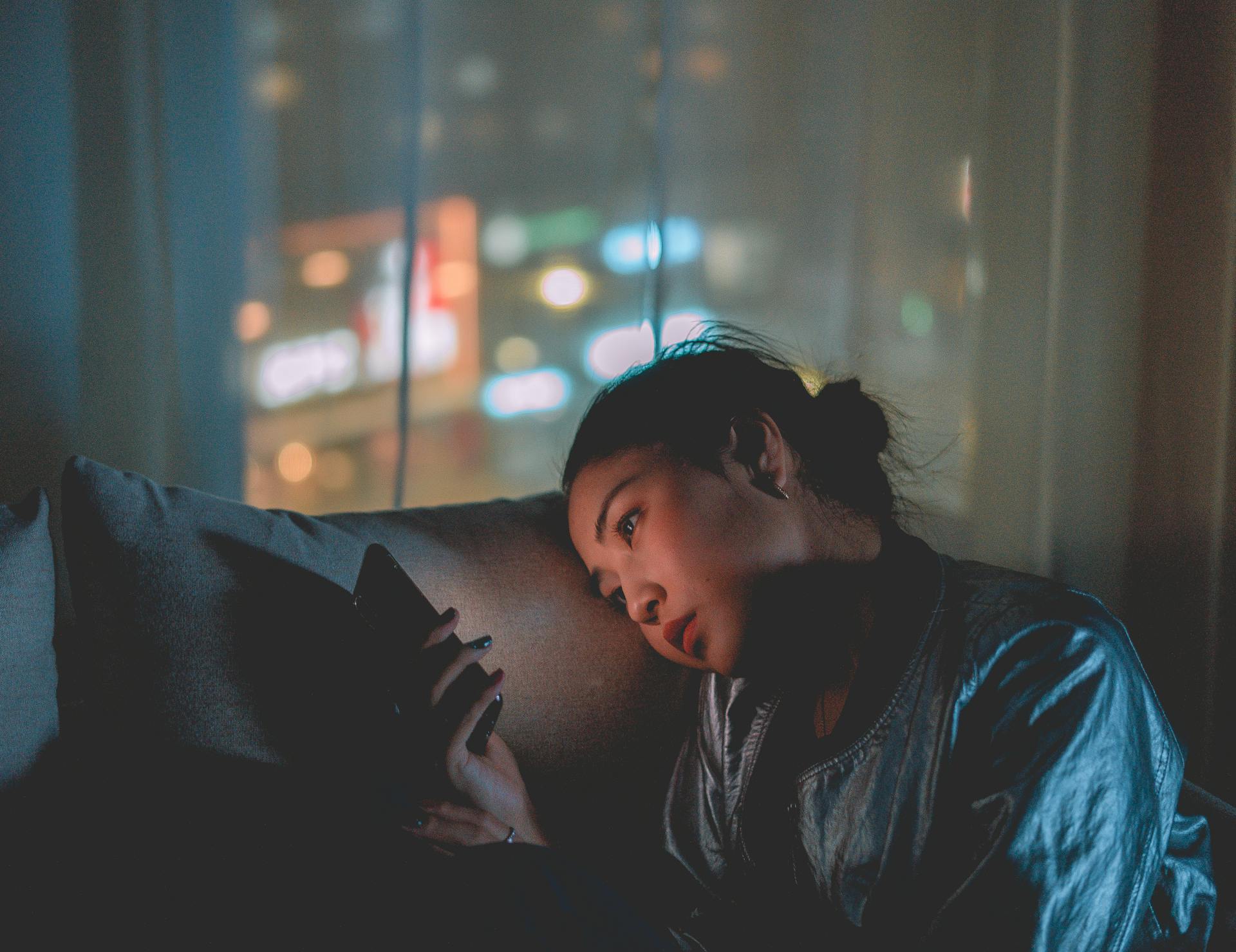 Une femme tenant un téléphone la nuit | Source : Pexels