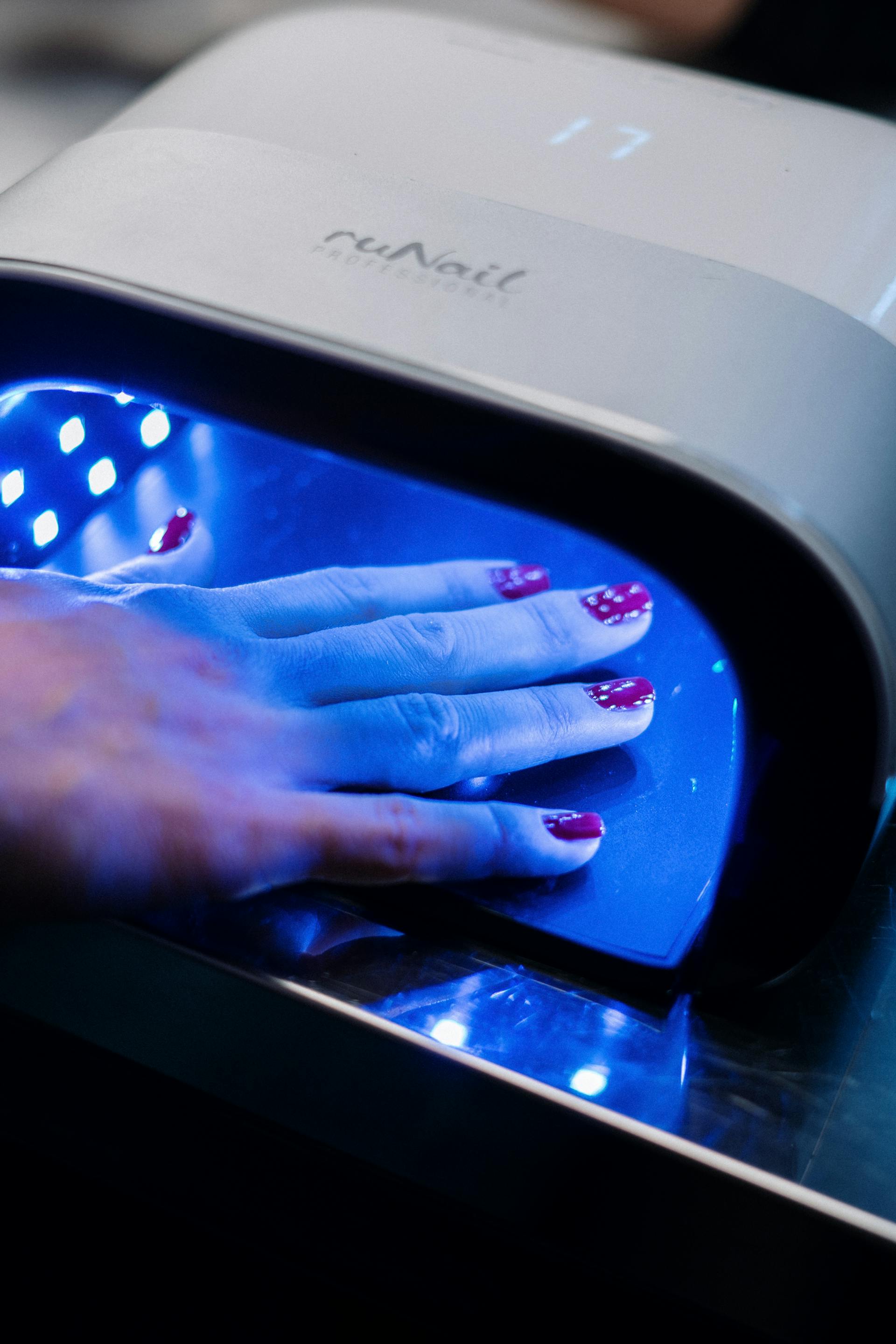Une main dans une machine à ongles UV | Source : Pexels