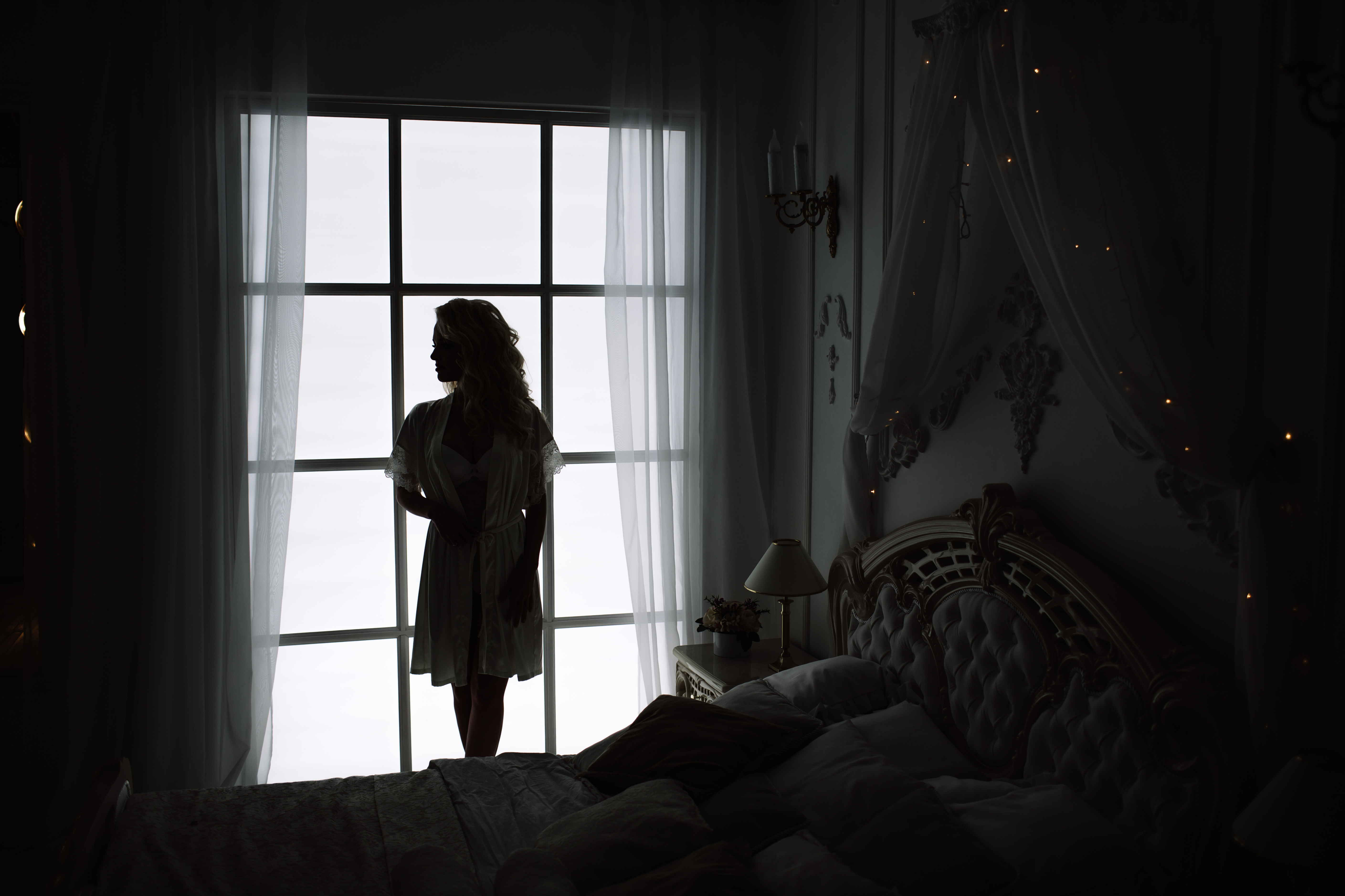 La silhouette d'une femme près de la fenêtre d'une chambre à coucher | Source : Shutterstock
