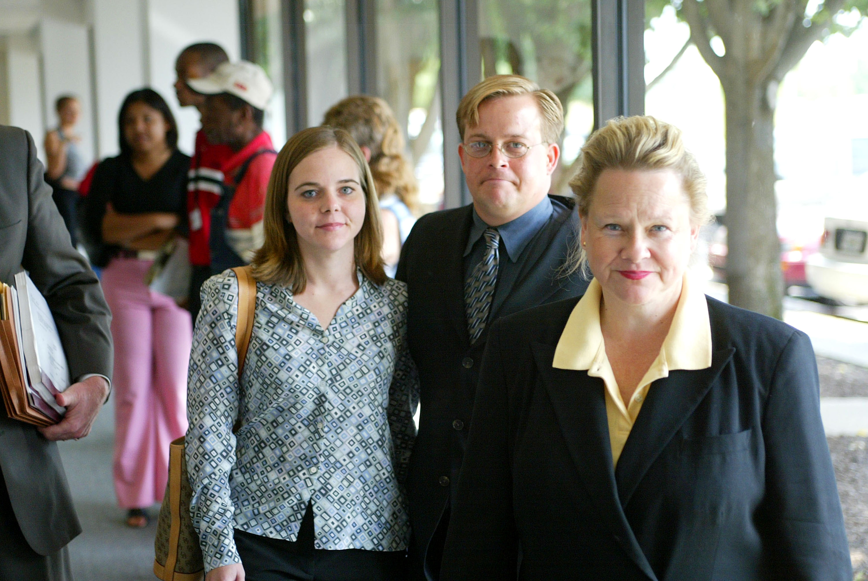 John Draper Witherspoon, âgé de 30 ans, marche avec sa mère (à droite) et sa fiancée, Jenny Stevens (à gauche), après sa comparution devant le tribunal pénal de Nashville, Tennessee, le 17 juillet 2003, pour des accusations de coups et d'agression et de vol aggravé. | Source : Getty Images