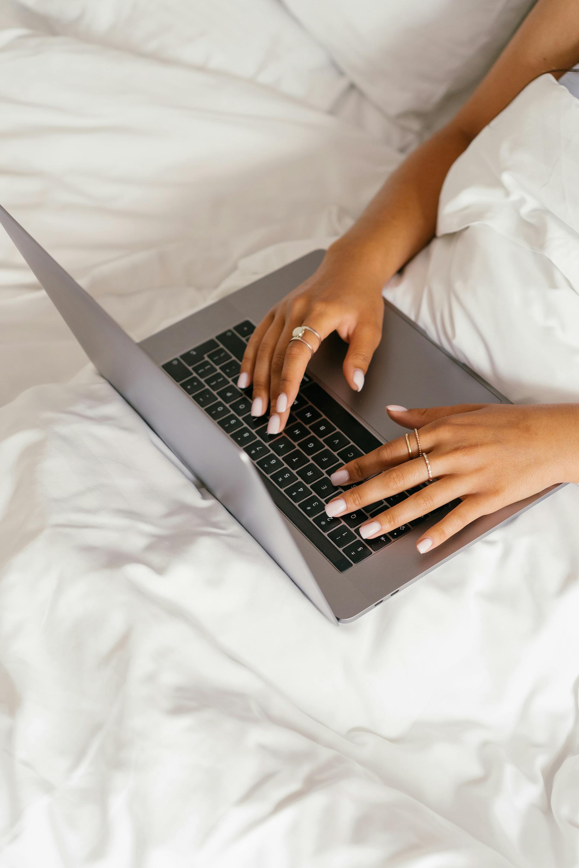 Une femme utilisant son ordinateur portable au lit | Source : Pexels