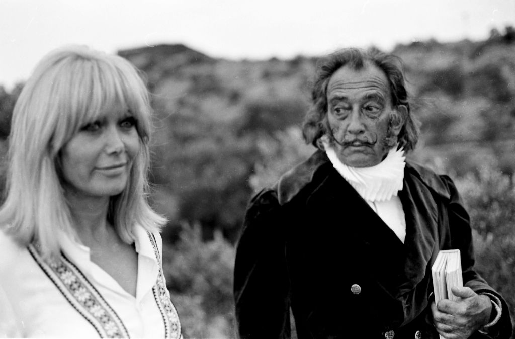 Le peintre espagnol Salvador Dali avec son modèle et muse Amanda Lear pendant le tournage de l'émission de télévision espagnole Doble Imagen à son domicile de Port Lligat, 26 janvier 1969, Gérone, Espagne. (Photo par Gianni Ferrari/Cover/Getty Images)